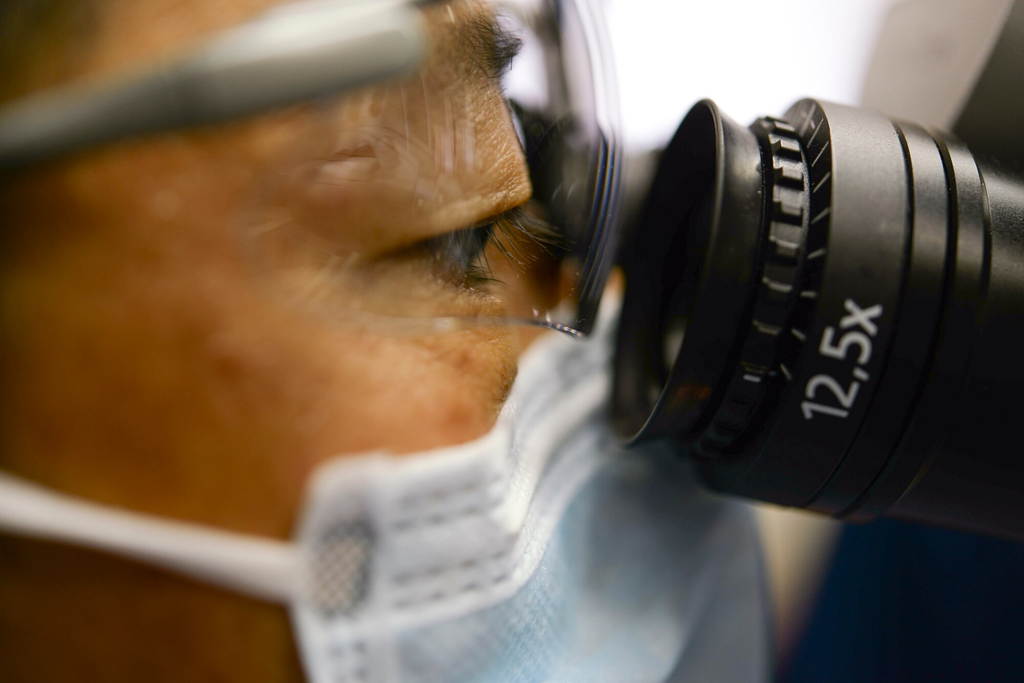 374th Dental Squadron Endodontics chief, Maj. Jongsun Kim, observes his patient through a magnification device while performing a root-end surgery April 16, 2015 Yokota Air Base, Japan. The 374 DS supports Yokota Air Base by performing more than 400 dental surgeries each year. (U.S. Air Force photo by Airman 1st Class Elizabeth Baker/Released)