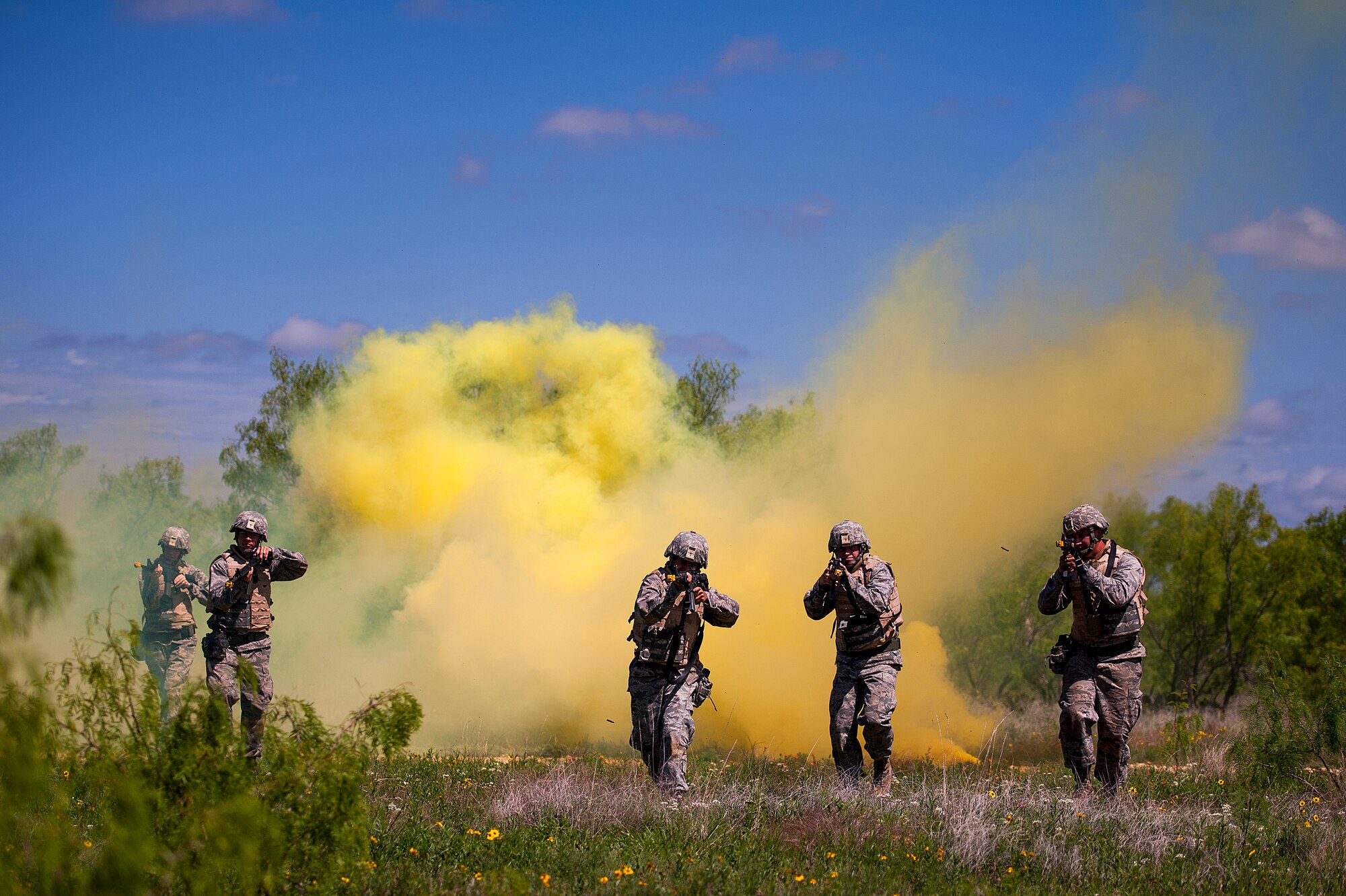 GOODFELLOW AIR FORCE BASE, Texas -- Angelo State University Air Force ROTC Detachment 847 cadets make their way through a cloud of yellow smoke during a field training exercise at a deployed simulation village near Camp Sentinel April 18. The FTX is designed to give cadets a broader understanding of what the Air Force is truly like before committing to serve. (U.S. Air Force photo/ Airman 1st Class Devin Boyer)