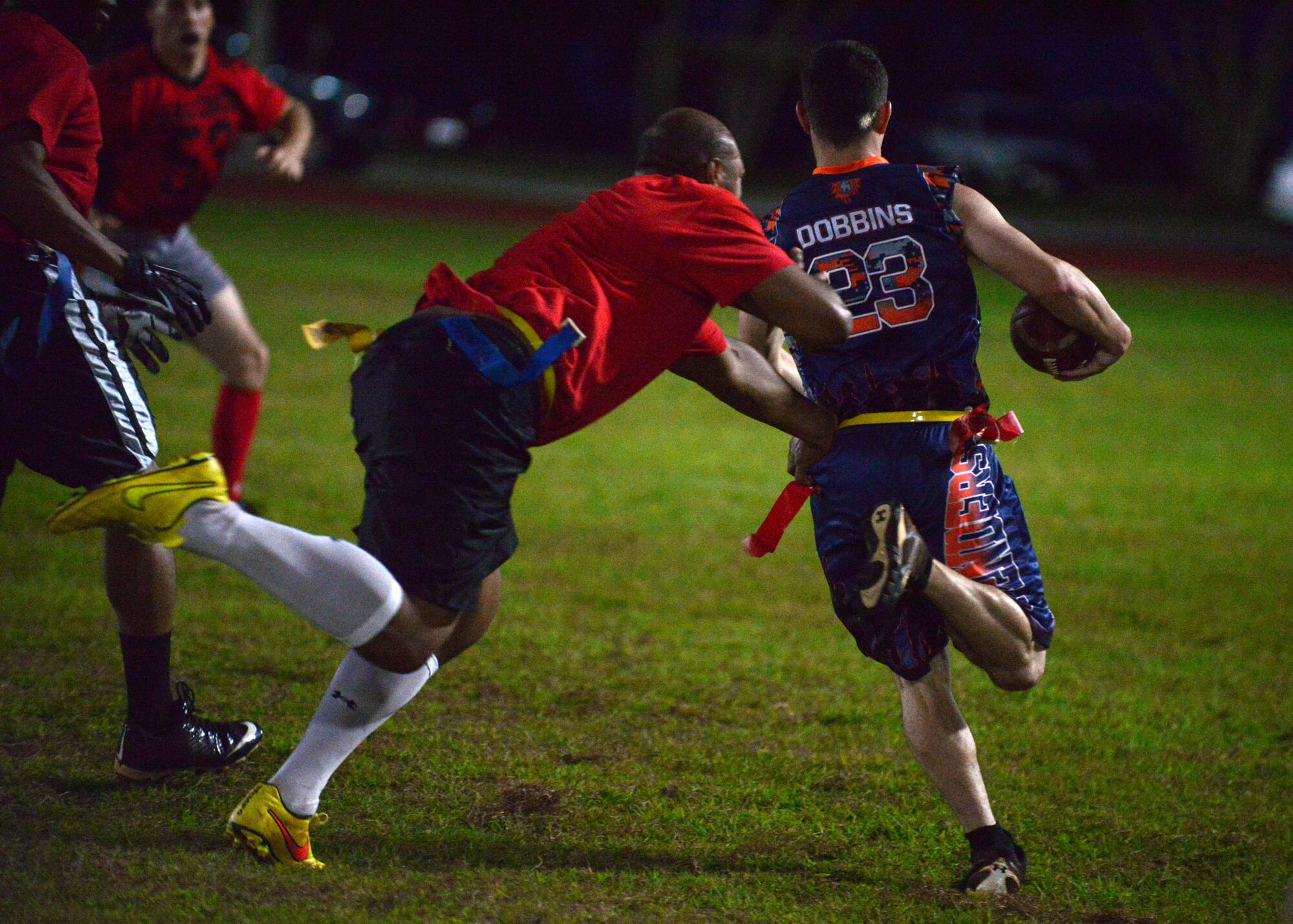 A 664th Combat Communications Squadron member attempts to pull a flag from a 36th Security Forces Squadron member during the flag football championship, April 20, 2015. The 36th SFS defeated the 664th CBCS 14-0 in the championship. (U.S. Air Force photo by Airman 1st Class Joshua Smoot/Released)