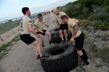 The Security Forces Defenders team conducts tire jumps as part of the Adventure Race XI on Laughlin Air Force Base, Texas, April 18, 2015. The Defenders had a team of seven members and they finished 4th overall with a time of two hours, 15 minutes and 24 seconds. (U.S. Air Force photo by Airman 1st Class Ariel D. Partlow)