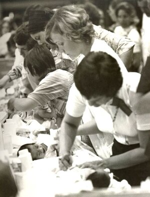 During Operation Baby Lift long lines of volunteers tend to the babies.  The babies were bathed, clothed, fed, provided medical care if needed, and simply comforted during their layover at either the Honolulu International Airport or MAC Terminal on Hickam Air Force Base. Operation Baby Lift ran from April 3-26, 1975 and evacuated more than 3,000 babies and young children, most of whom were orphans, to the U.S. (U.S. photo provided by 15 WG historian office)