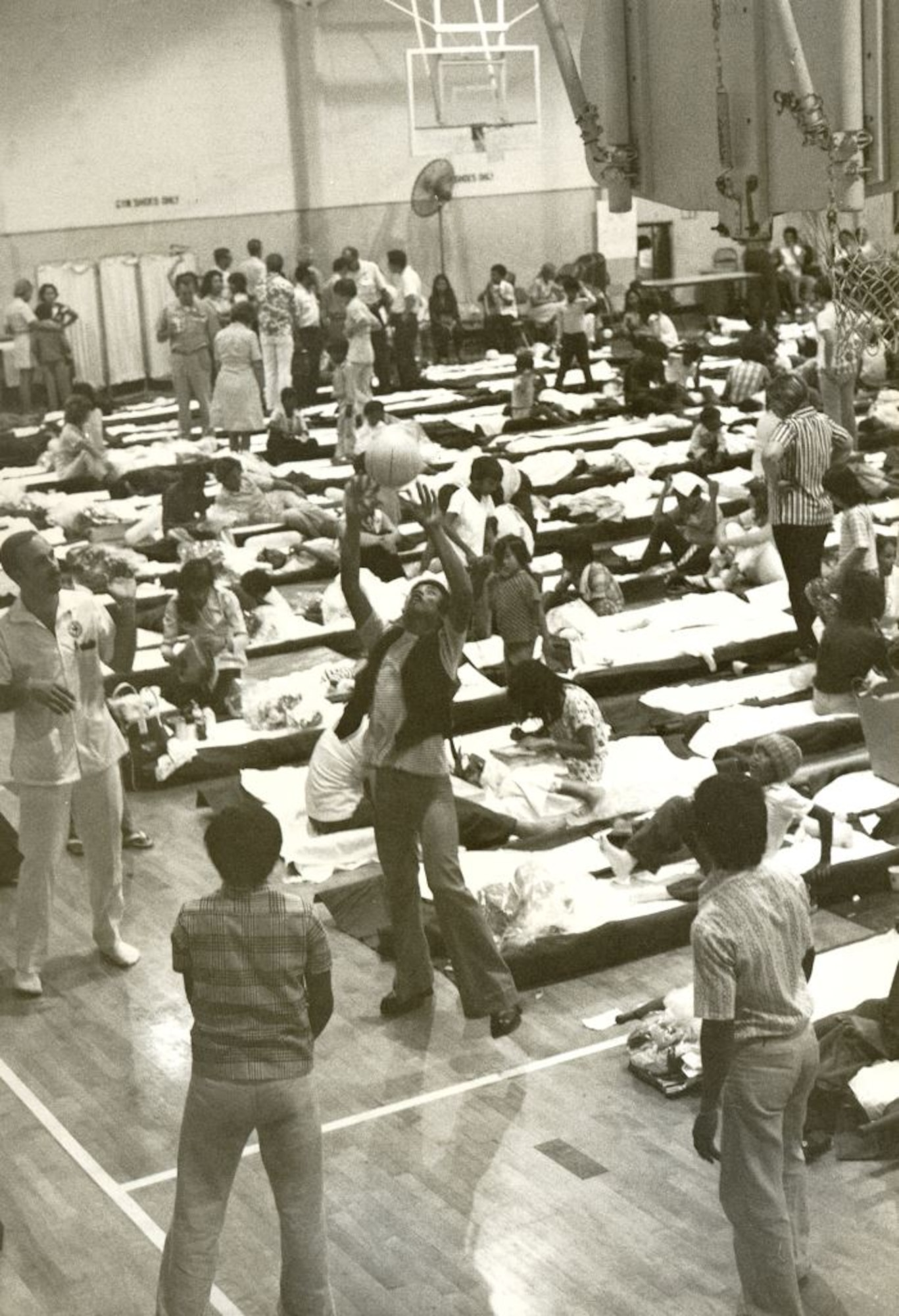 During Operation New Life,  to accommodate flights with longer layovers litters were set up on the Hickam Air Force Base, Hawaii,  gymnasium floor. The practice became common in late April and throughout May 1975 due to the increasing number of refugees. Operation New Life, ran from April 23 to November 1, 1975, airlifting over 100,000 evacuees and refugees from South Vietnam. (U.S. Air Force photo provided by 15 WG historian office)