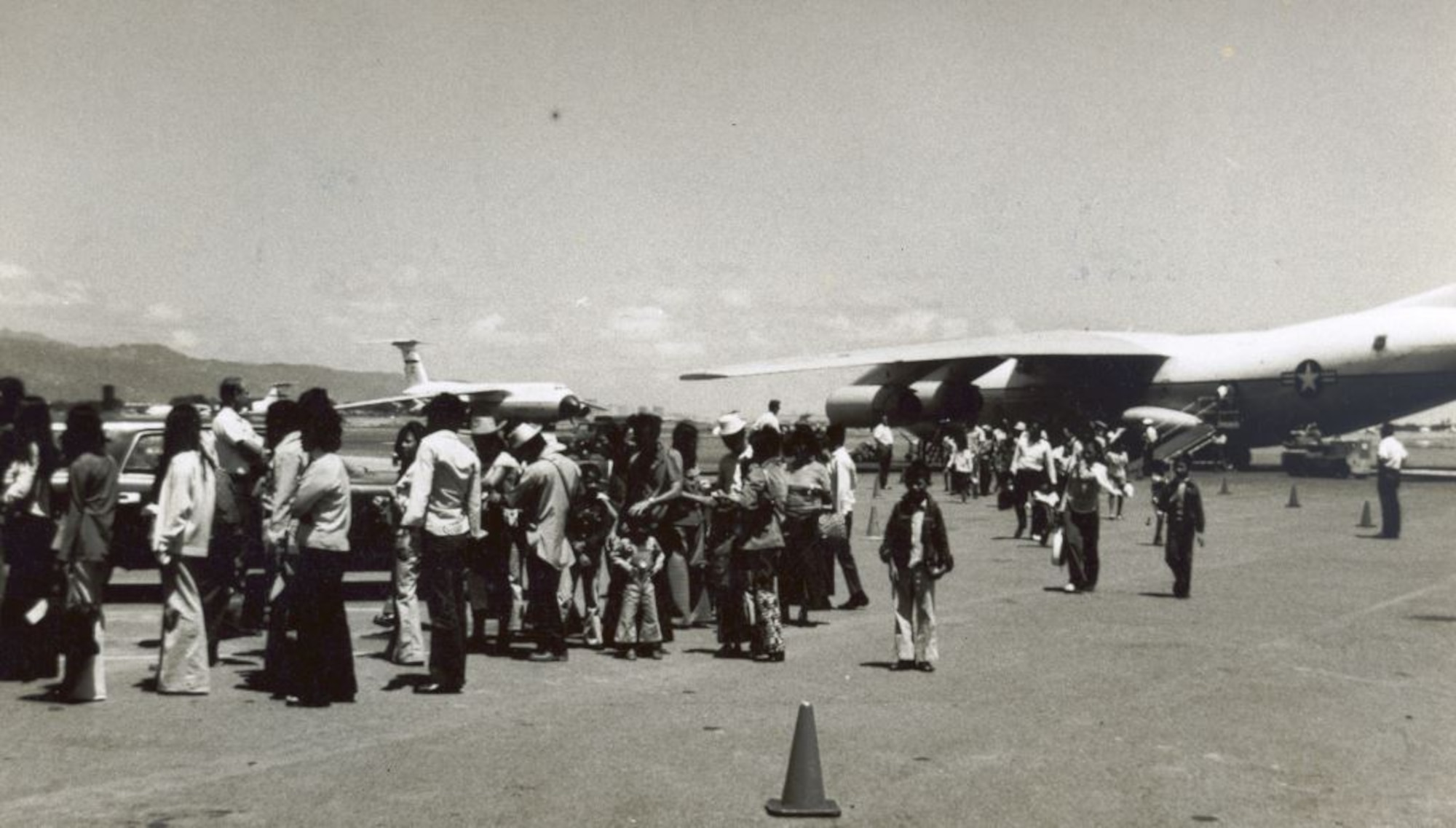 Refugees fleeing South Vietnam in 1975 streamed across the flightline on Hickam Air Force Base, Hawaii, after arriving on C-141 aircraft during Operation New Life. Operation New Life ran from April 23- November 1, 1975, airlifting over 100,000 evacuees and refugees from South Vietnam.(U.S. Air Force photo provided by 15 WG historian office)