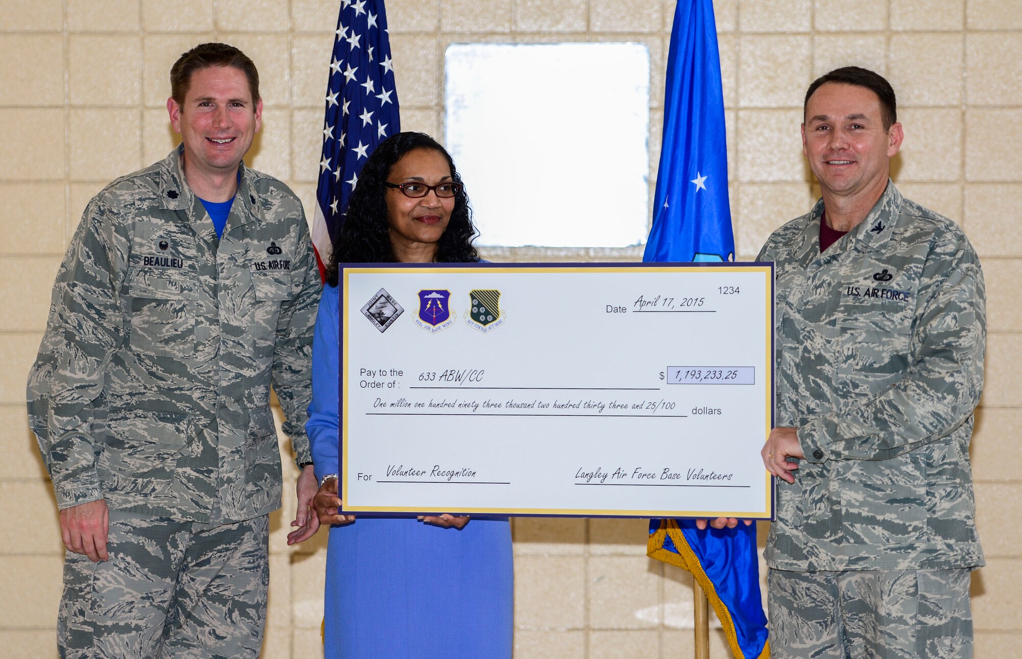 U.S. Air Force Col. Kevin Head, 633rd Mission Support Group commander, and Lt. Col Gregory Beaulieu, 633rd Force Support Squadron commander, accept a check from the Joint Base Langley-Eustis volunteers during the 2015 JBLE Volunteer Salute at Langley Air Force Base, Va., April 17, 2015. The event recognized JBLE Service members and civilians for their outstanding volunteerism. (U.S. Air Force photo by Senior Airman Kayla Newman/Released)