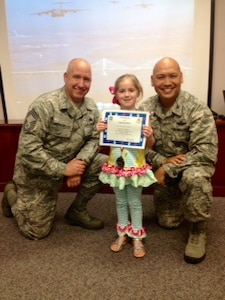 Chief Master Sgt. Christopher Robinson, 437th Maintenance Group superintendent (left) and Col. Jimmy Canlas, 437th Airlift Wing vice commander present Kinsley Wardlow with a medal and certificate during the Little Heroes ceremony April 16, 2015 at the Airman and Family Readiness Center at Joint Base Charleston, S.C. Held twice a year, once in April and again in October, the ceremony is an event for children of recent or current
deployed or remote parents. This  event is a way for senior leaders to thank the base's littlest members for all of their hard work and sacrifice during the deployment or remote tour. Captain Timothy Sparks, JB Charleston deputy commander and Chief Master Sgt. Jan Menard, 628th Medical Group superintendent Sparks and Chief Menard, handed out the medals and certification for the 628th Air Base Wing. Kinsley is the daughter of April and Staff Sgt. James Wardlow, 437th Aircraft Maintenance Squadron. (Courtesy photo)