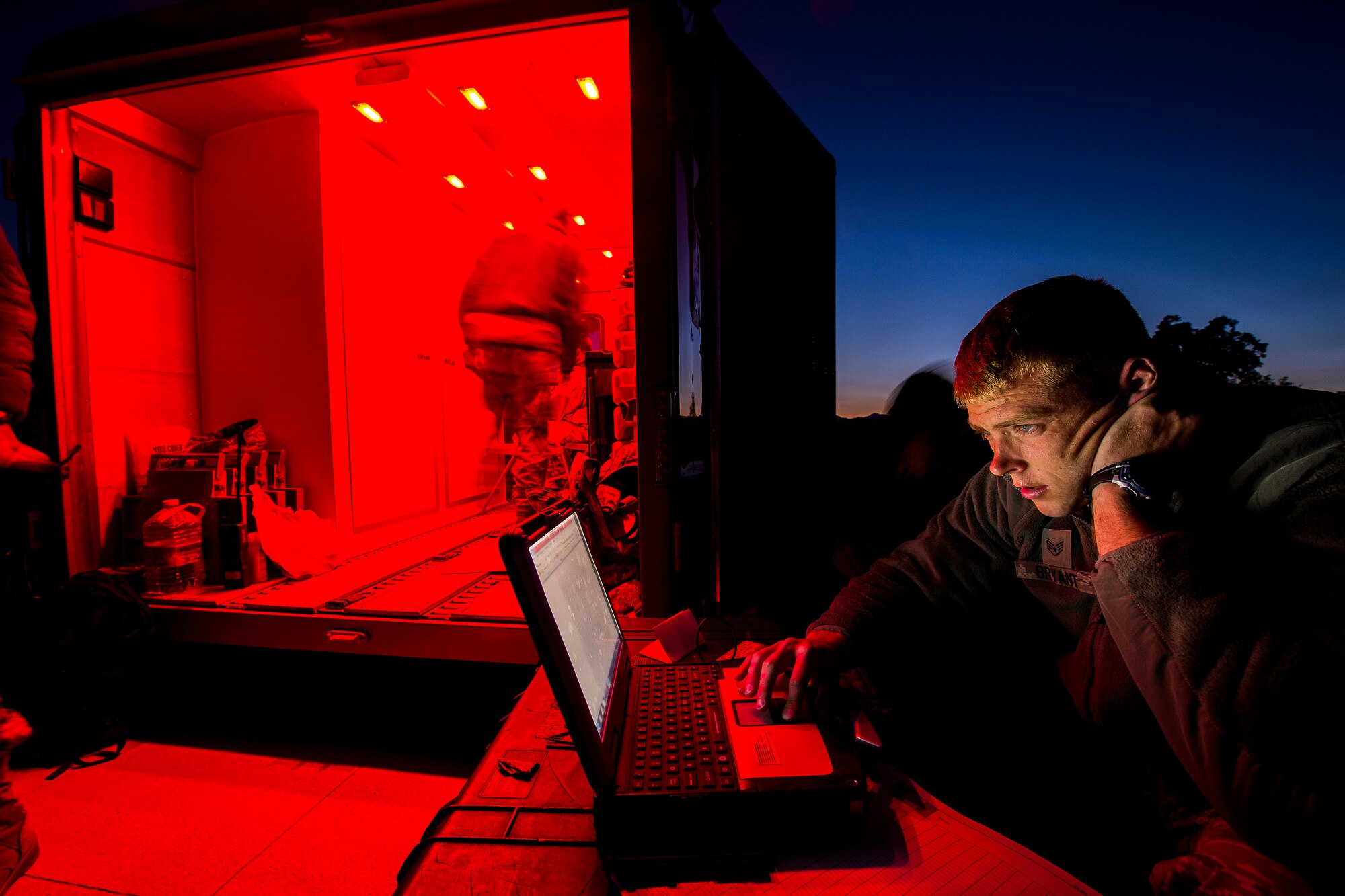 Staff Sgt. Daniel Bryant, Aerial Port Lead for the 570th Global Mobility Squadron, coordinates cargo movement for aircraft performing night landings at Fort Hunter Liggett, Calif. during Exercise Golden Hydra on March 31, 2015. (Photo by U.S. Air Force Photojournalist Tech. Sgt. Matthew Hannen)  