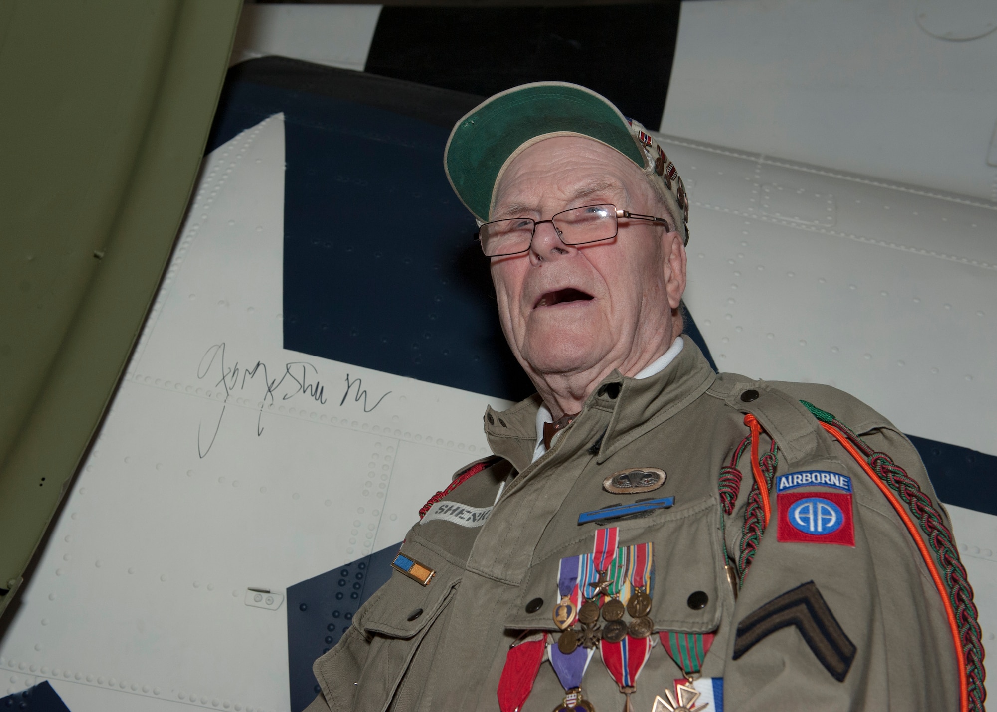 George Shenkle poses after autographing the roundel on the side of a C-47A Skytrain April 18, 2015, at the Air Mobility Command Museum,  near Dover Air Force Base, Del. Shenkle signed the roundel in the same fashion that he and his fellow paratroopers signed  hours before jumping into Normandy, France on D-Day, June 6, 1944. (U.S. Air Force photo/Airman 1st Class Zachary Cacicia)