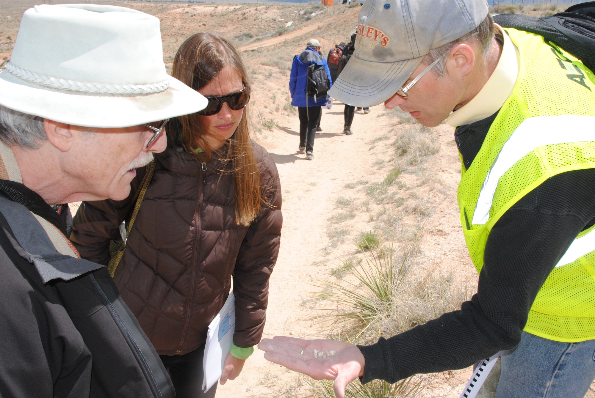 Collin Plank (right), an earth scientist with the engineering consultant contractor AECOM, shares rocks samples with members of the community participating in a Bulk Fuels Facility field trip April 18 near Tijeras Arroyo, south of the Albuquerque International Sunport. Plank was a member of a team of specialists  helping participants to understand hydrology as it relates to the BFF contamination plume. (U.S. Air Force photo by Jim Fisher)
