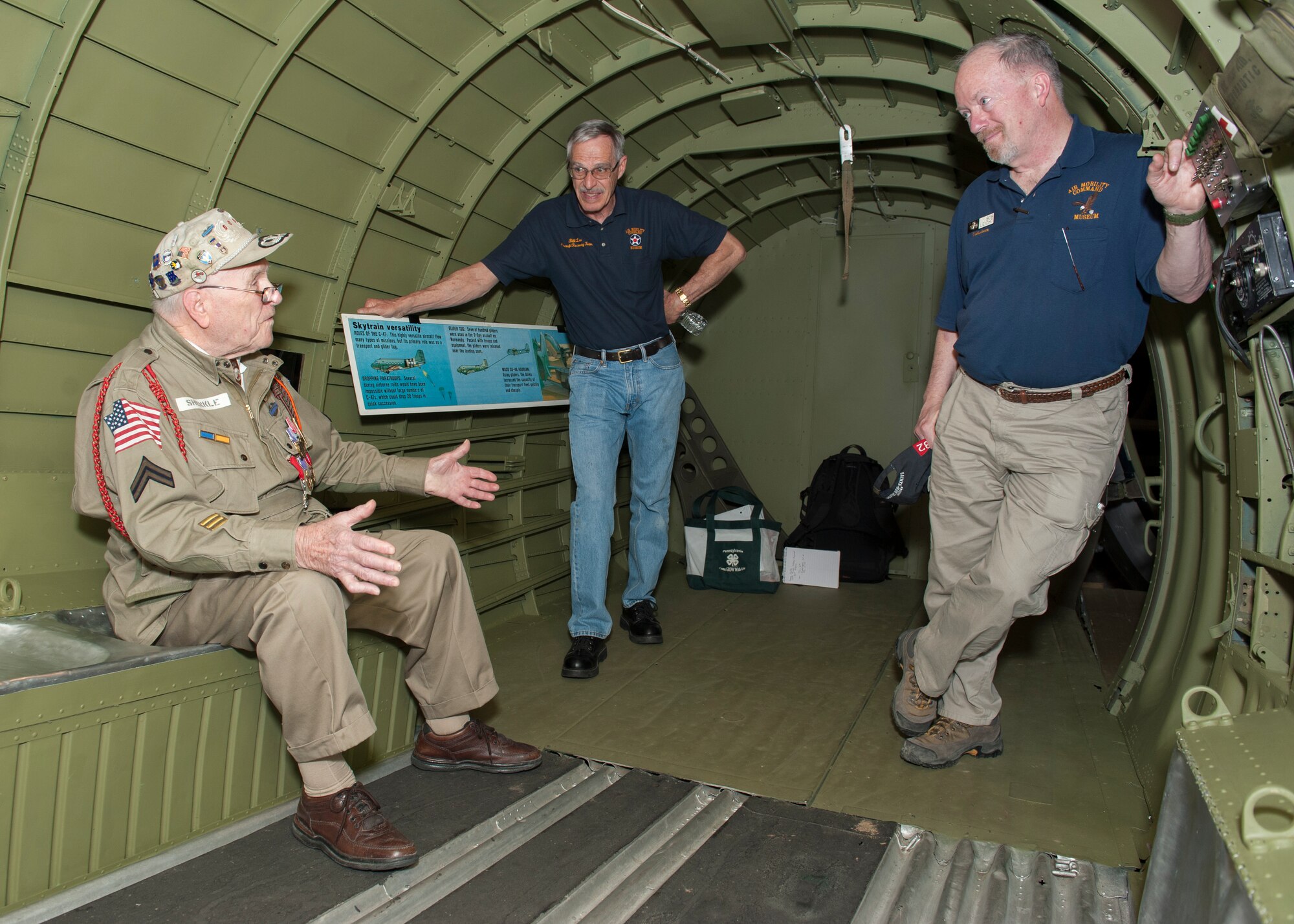 George Shenkle, left, talks to Bill Lee, Air Mobility Command Museum volunteer, center, and Bob Leicht, AMC Museum volunteer, inside a C-47A Skytrain April 18, 2015, at the AMC Museum on Dover Air Force Base, Del. Lee and Leicht are part of a restoration team that recently restored the interior of the aircraft to an accurate World War II-era presentation. (U.S. Air Force photo/Airman 1st Class Zachary Cacicia)