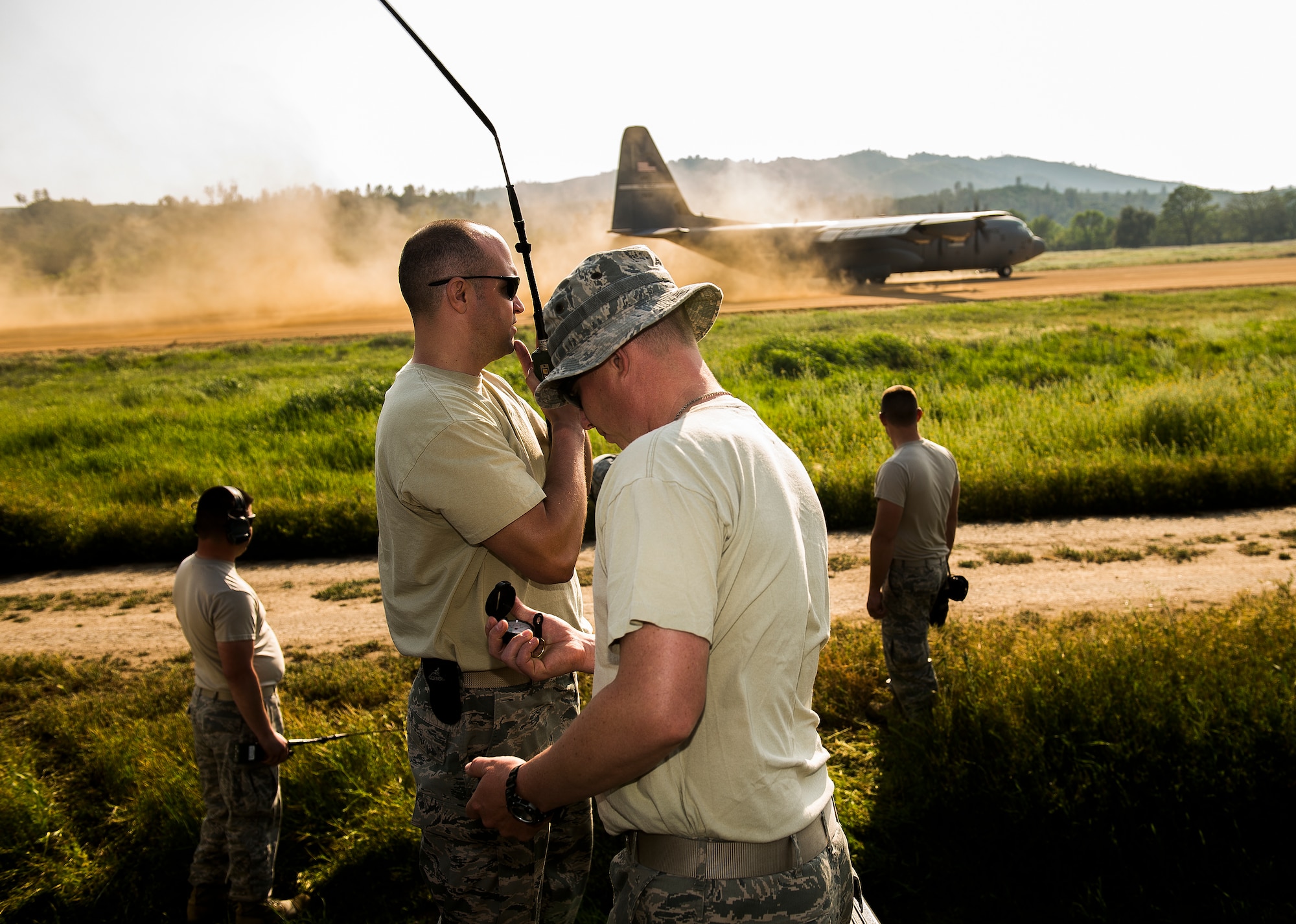 Capt. Jake Becker from the 571st Global Mobility Readiness Squadron and TSgt Josh Hollenbeck from the 570th Global Mobility Readiness Squadron, perform landing zone safety operations for a C-130 Hercules Aircraft landing on a dirt runway at Fort Hunter Liggett, Calif. during Exercise Golden Hydra on March 31, 2015. (Photo by U.S. Air Force Photojournalist Tech. Sgt. Matthew Hannen)  