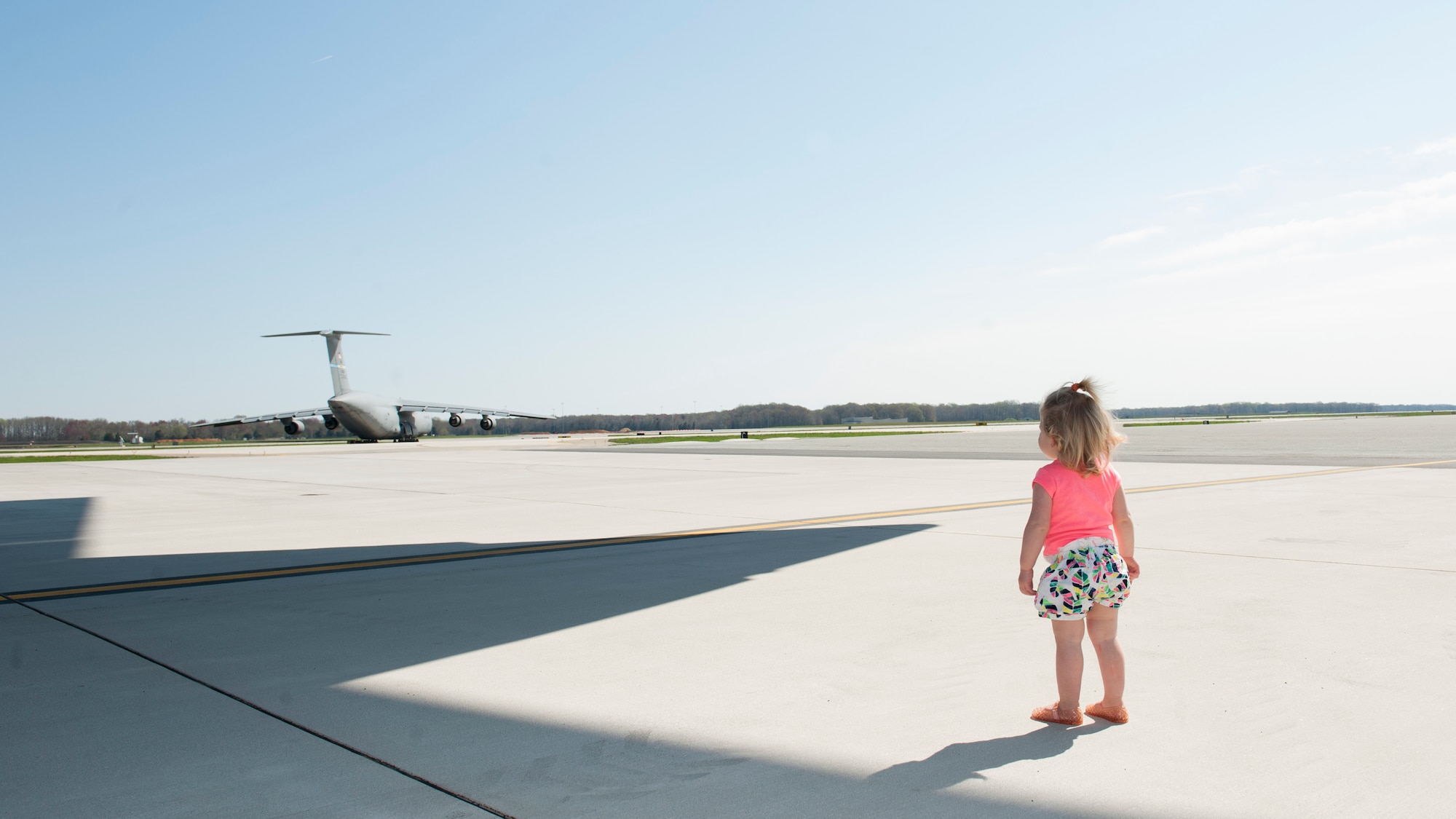 Annika Negron, daughter of Capt. Evin Negron, 3d Airlift Squadron pilot, watches a taxiing C-5M Super Galaxy April 18, 2015, at Dover Air Force Base, Del. Annika and her family toured the flight line and a C-17A Globemaster III that was on display. (U.S. Air Force photo/Airman 1st Class Zachary Cacicia)