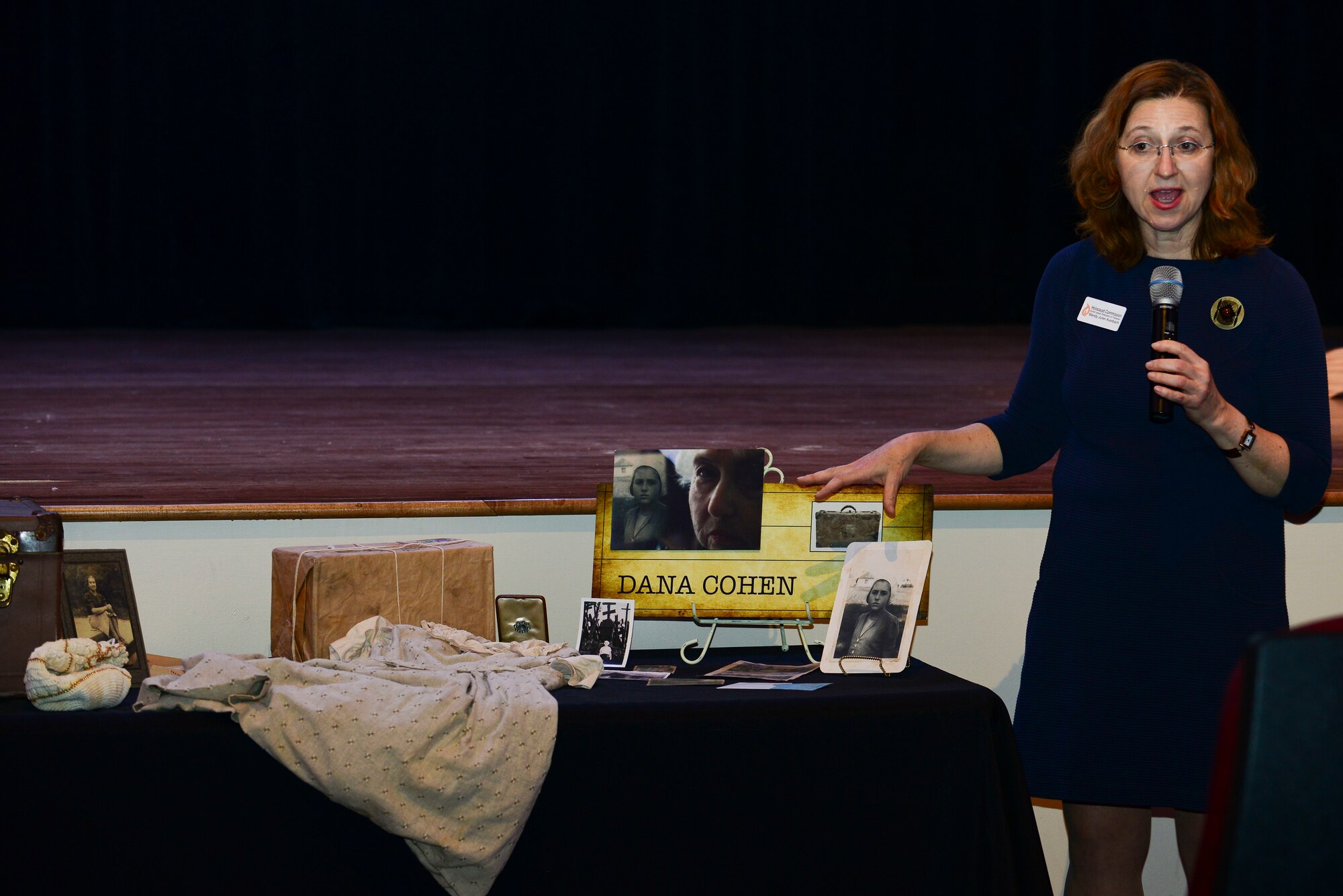 Wendy Auerbach, Holocaust Commission United Jewish Foundation of Tidewater guest speaker, speaks to the audience at the Holocaust Remembrance Ceremony at Fort Eustis, Va., April 17, 2015. Auerbach explained how the items displayed helped Dana Cohen, a Holocaust survivor, get through two years in Siberia. (U.S. Air Force photo by Senior Airman Kimberly Nagle/Released)