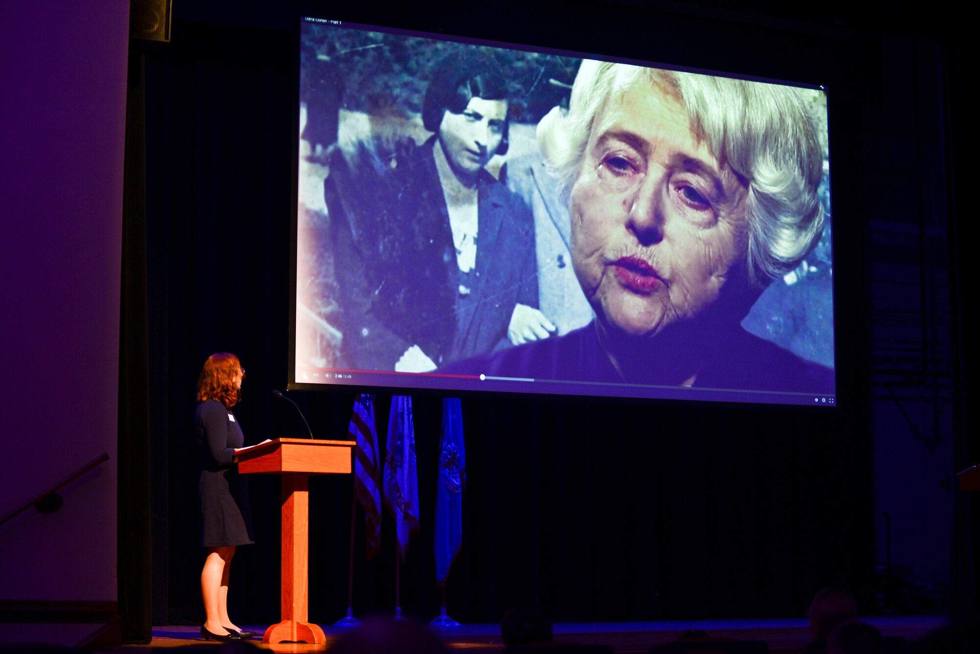 Wendy Auerbach, Holocaust Commission, United Jewish Foundation of Tidewater guest speaker, watches a clip from the story of Dana Cohen during the Holocaust Remembrance Ceremony at Fort Eustis, Va., April 17, 2015. Cohen is one of the last few Holocaust survivors still telling her and her mother’s story of survival. (U.S. Air Force photo by Senior Airman Kimberly Nagle/Released)