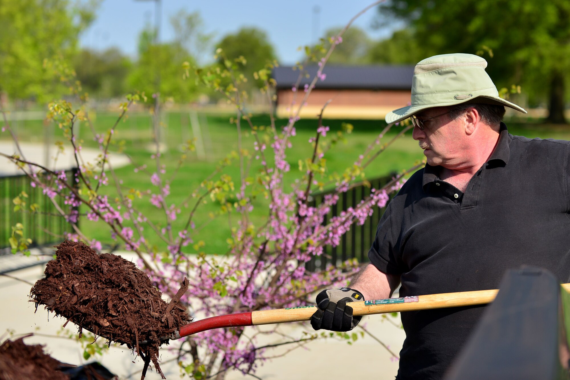 John Wilson, Air Force Civil Engineer Center installation support team restoration program manager, shovels mulch at Fort Eustis, Va., April 21, 2015. The mulch was put into drains as part of a waterway restoration project for Earth Week. The mulch is a part of clean filtering processes that removes dangerous materials from reaching local Virginia waterways. (U.S. Air Force photo by Staff Sgt. Natasha Stannard/Released) 
