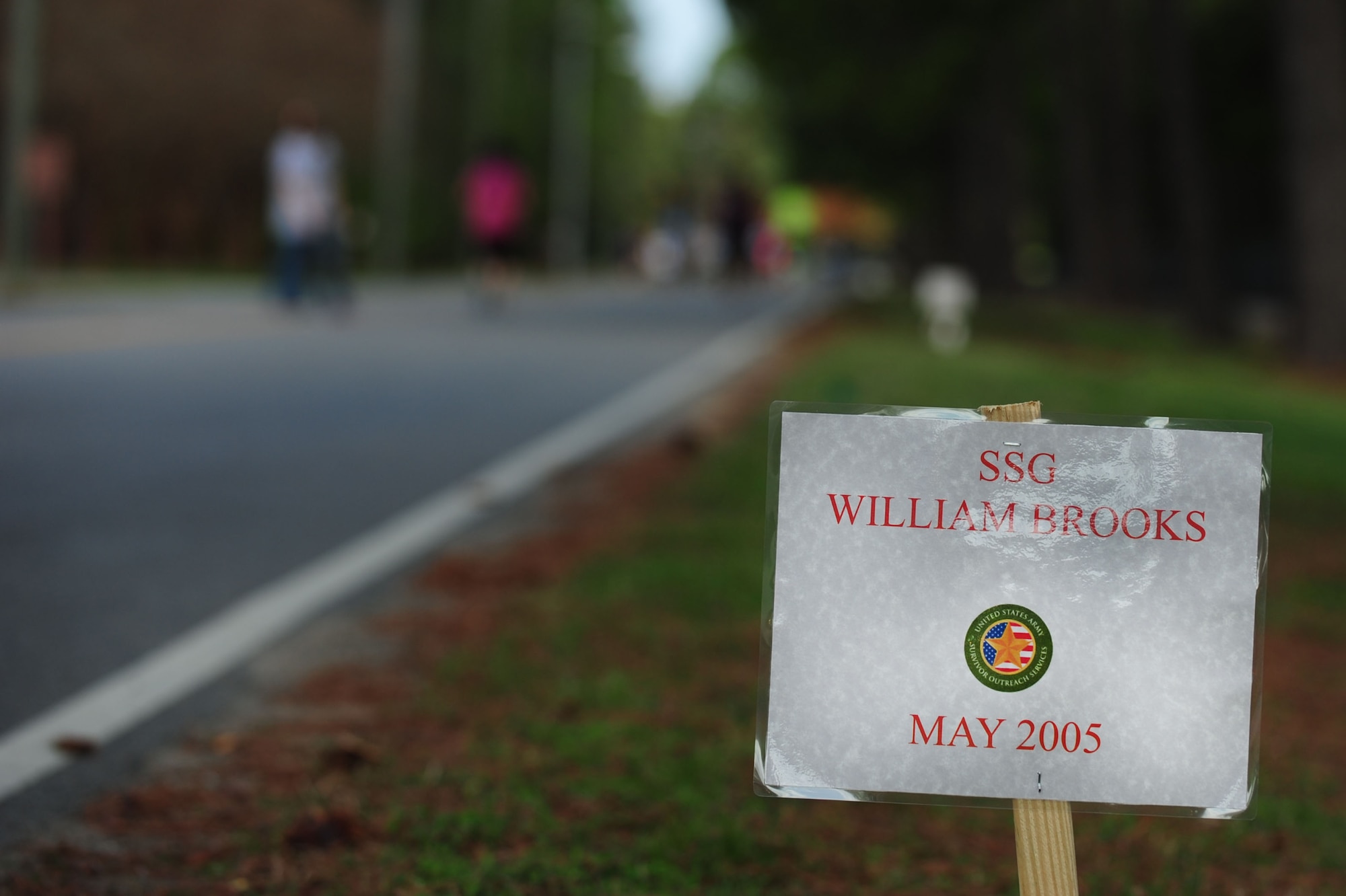 Warrior Run participants run past markers identifying deceased Service members at Fort Eustis, Va., April 18, 2015. Markers were placed throughout the run’s 5K and 10K courses as a reminder of the ultimate sacrifice Service members of all branches gave to defend their country.  (U.S. Air Force photo by Staff Sgt. Natasha Stannard/Released)