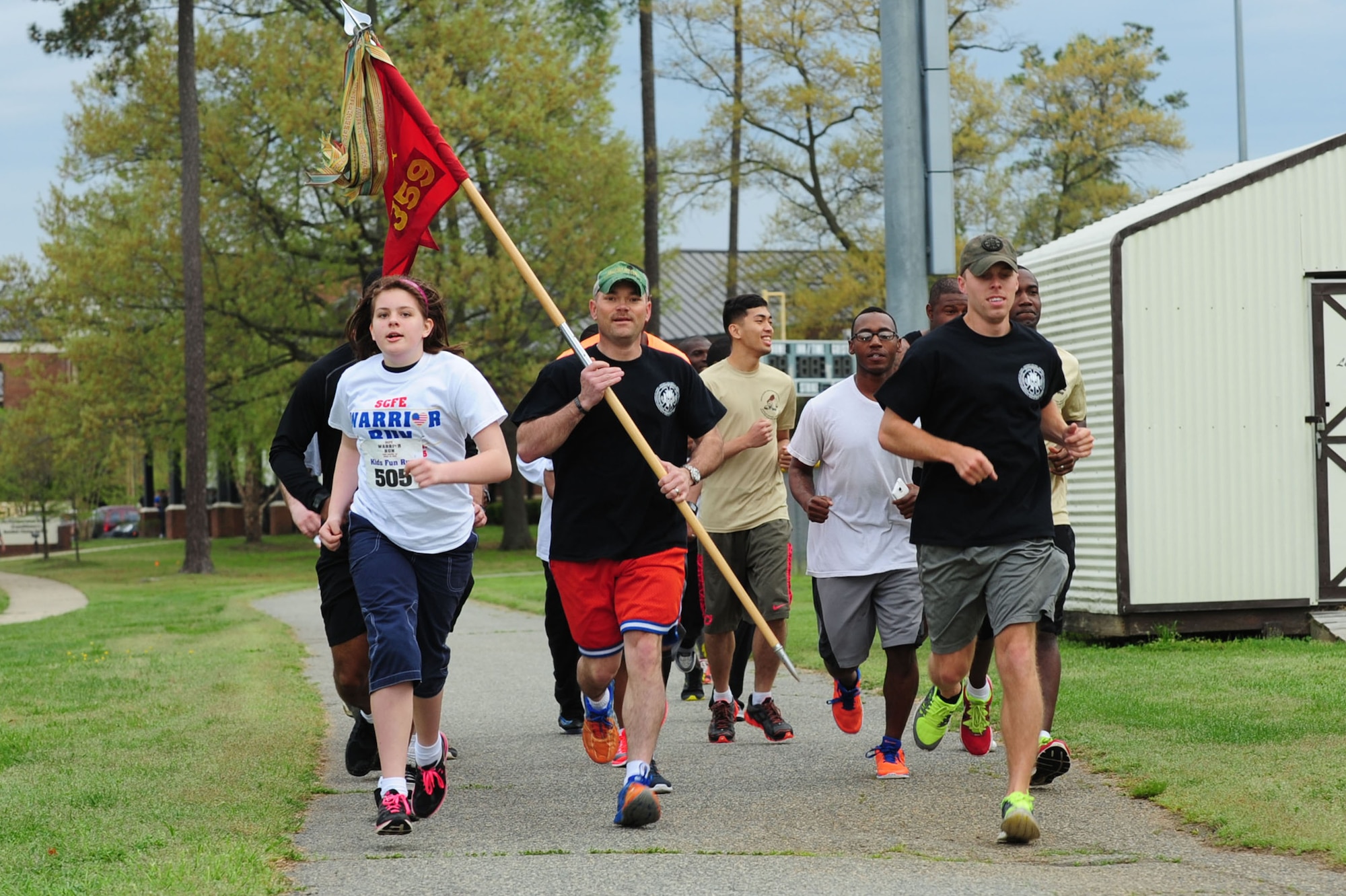 Members of the U.S. Army 359th Inland Cargo Transfer Company, 10th Transportation Battalion, 7th Transportation Brigade (Expeditionary), run with  Eniale Nouv, left, at the Warrior Run at Fort Eustis, Va., April 18, 2015. Nouv’s mother was one of three Service members from the 359th ICTC that was killed-in-action in Afghanistan in 2013.  (U.S. Air Force photo by Staff Sgt. Natasha Stannard/Released) 