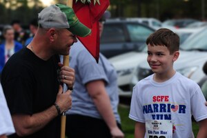 U.S. Army Staff Sgt. Rodney Golden, race participant from the 359th Inland Cargo Transfer Company, 10th Transportation Battalion, 7th Transportation Brigade (Expeditionary), left, speaks with Derrik Nouv at the Warrior Run at Fort Eustis, Va., April 18, 2015. The Spouse’s Club of Fort Eustis hosted the Warrior Run in an effort to support Wounded Warriors and their families. The 359th ICTC ran with Nouv and his sister in honor of the children’s mother who was killed-in-action in 2013. (U.S. Air Force photo by Staff Sgt. Natasha Stannard/Released) 
