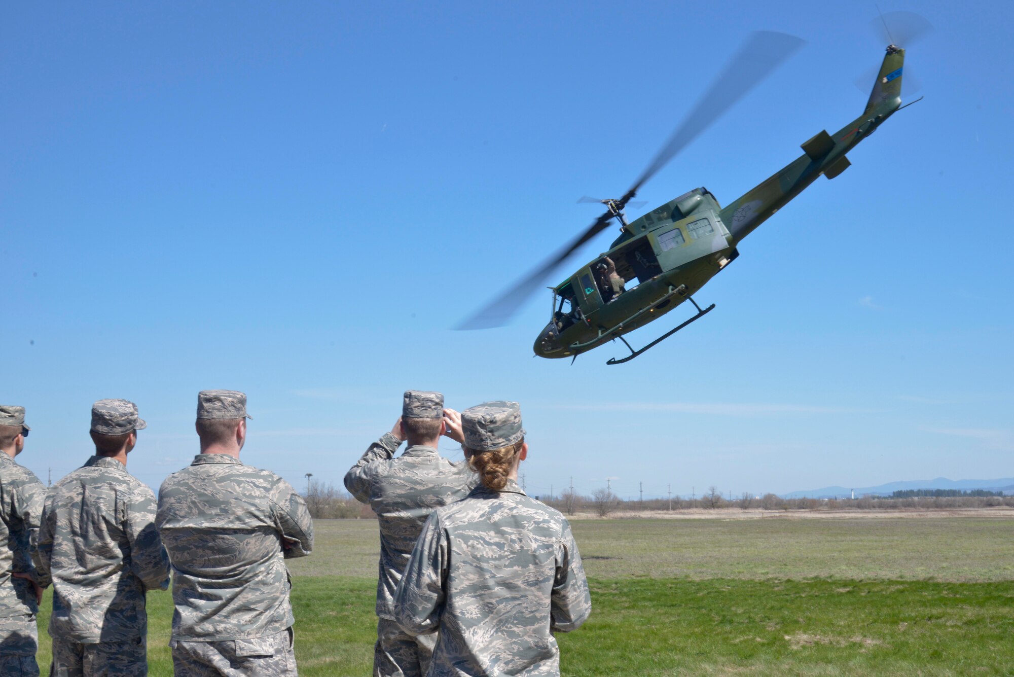 Central Washington University Air Force ROTC students take photos and record videos while members of the 36th Rescue Flight conduct a UH-1N Iroquois helicopter demonstration during a base wide tour April 17, 2015, at Fairchild Air Force Base, Wash. Students were given a chance to see and explore not only the main part of the base, but also what the Survival, Evasion, Resistance and Escape School teaches students going through the training. (U.S. Air Force photo/Senior Airman Janelle Patiño)