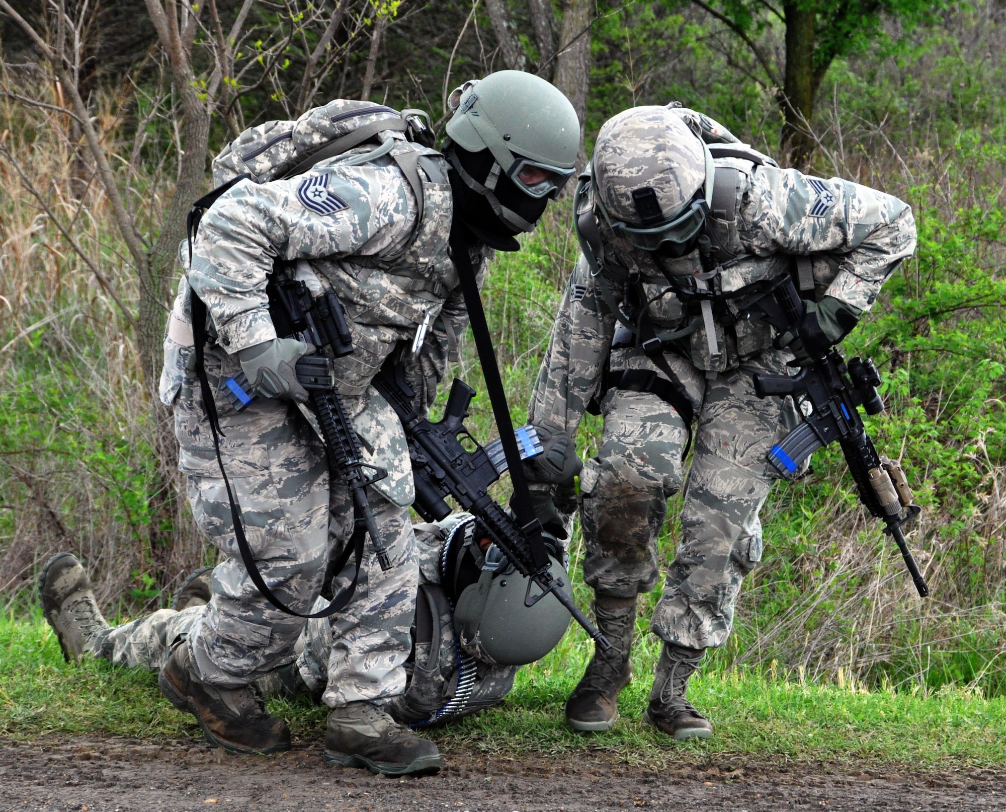 Members of the 931st Security Forces Squadron and 931st Civil Engineer Squadron pulls a "wounded" Airman to safety during a combat training exercise at Camp Gruber Training Center, Okla., April 15, 2015.  More than 80 members of the 931 SFS and 931 CES participated in ten days of training at Camp Gruber, which included  land navigation, weapons training, tactical movements, convoy operations, base defense, room clearing procedures, foot patrols, military operations on urban terrain (MOUT) and combat lifesaving. (U.S. Air Force photo by Capt. Zach Anderson)