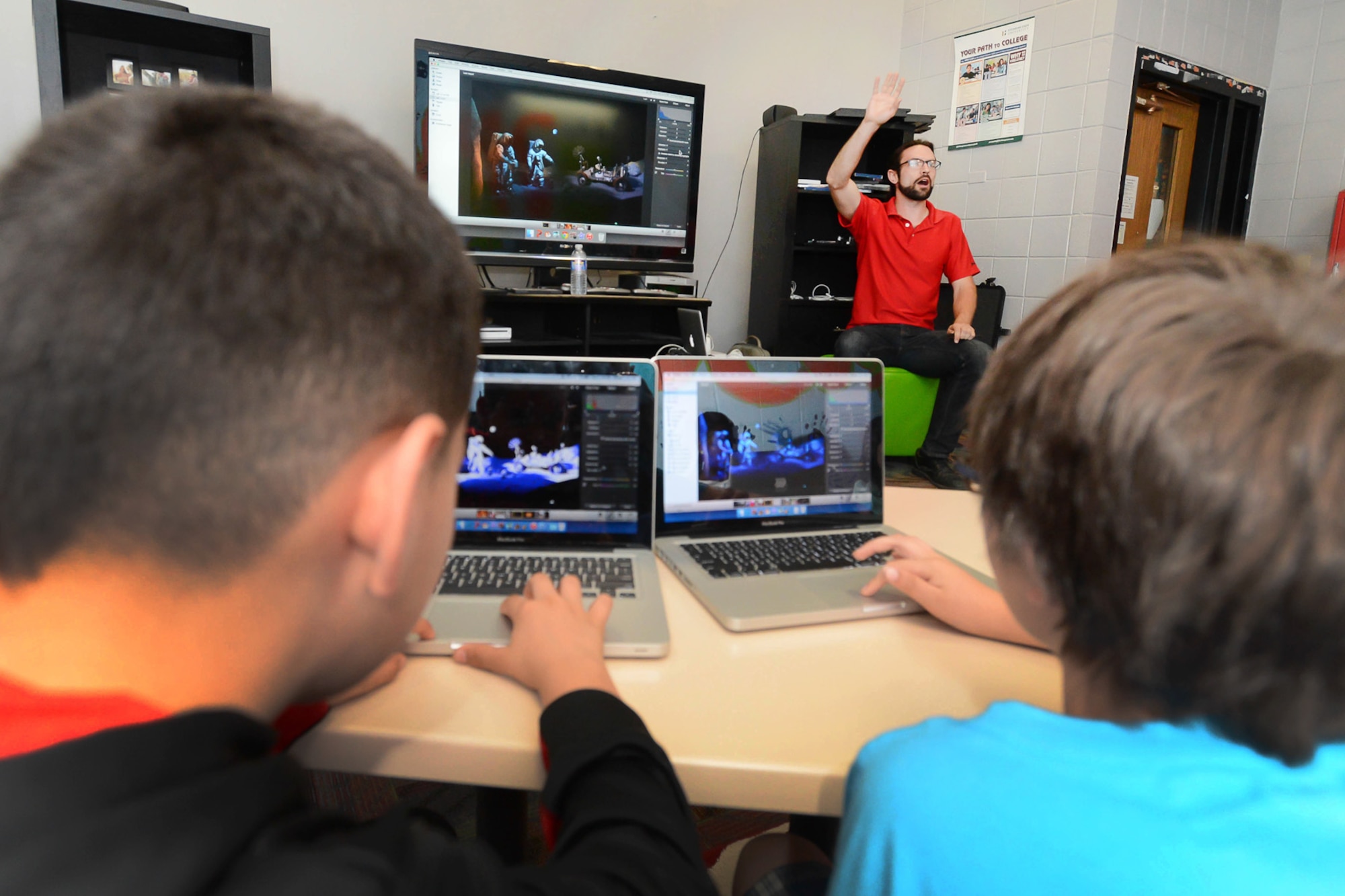 Corey Kline, a Tech Camp instructor, shows students how to use iPhoto editing software during a week-long camp at the Youth Center, April 20. Teens had the opportunity to design logos and video games, shoot a movie trailer, learn digital photography, write a song and more as part of the April school vacation Tech Camp. (U.S. Air Force photo by Jerry Saslav)