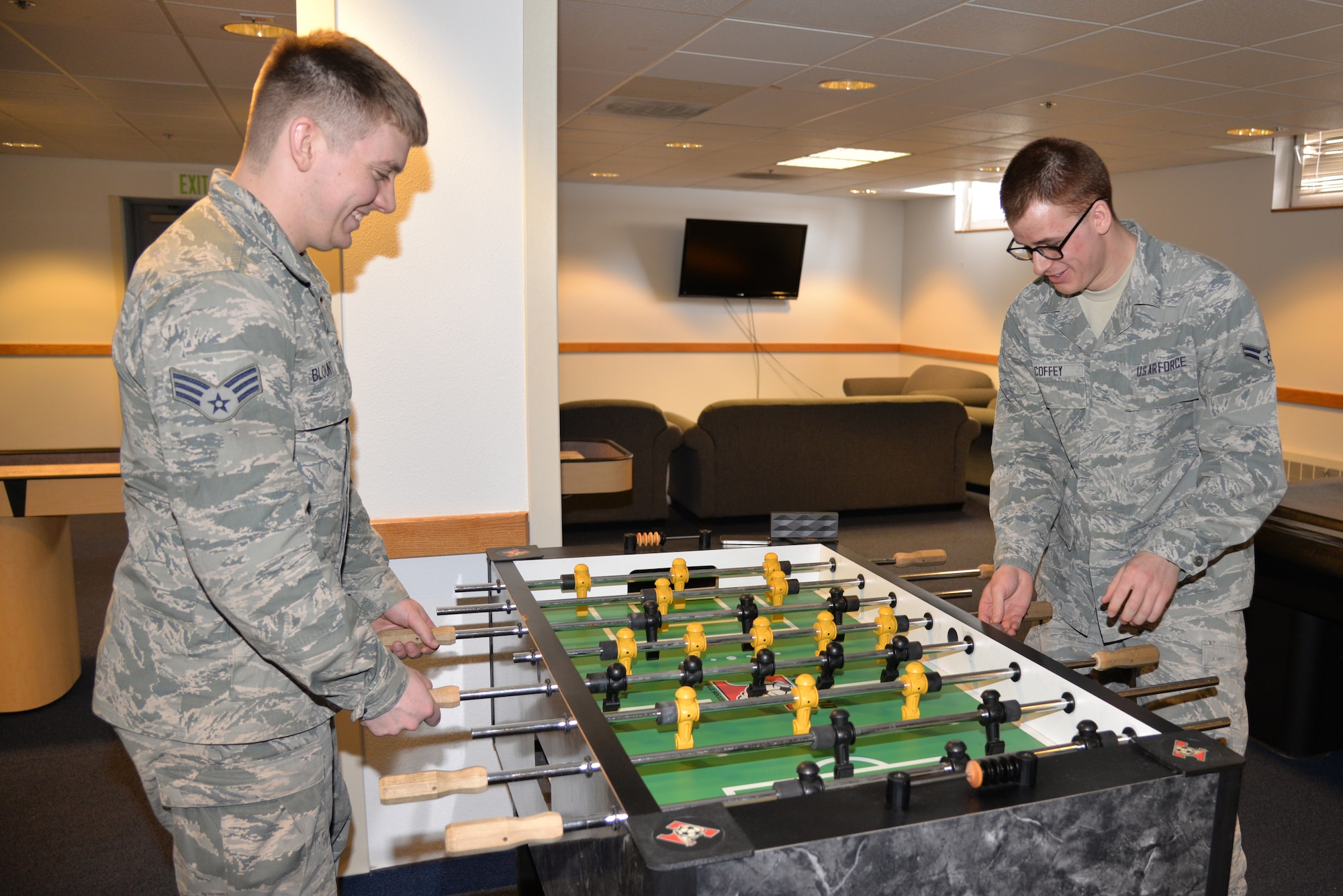 Senior Airman Kenneth Blount, 354th Force Support Squadron and Airman 1st Class Jonathan Coffey, 354th Communications Squadron, play a game of foosball on a new table in their dormitory’s common room. Dormitory residents are able to enjoy approximately $30,000 in quality of life upgrades to the common rooms of dormitory buildings. (U.S. Air Force photo by Staff Sgt. Kirsten Wicker/Released)