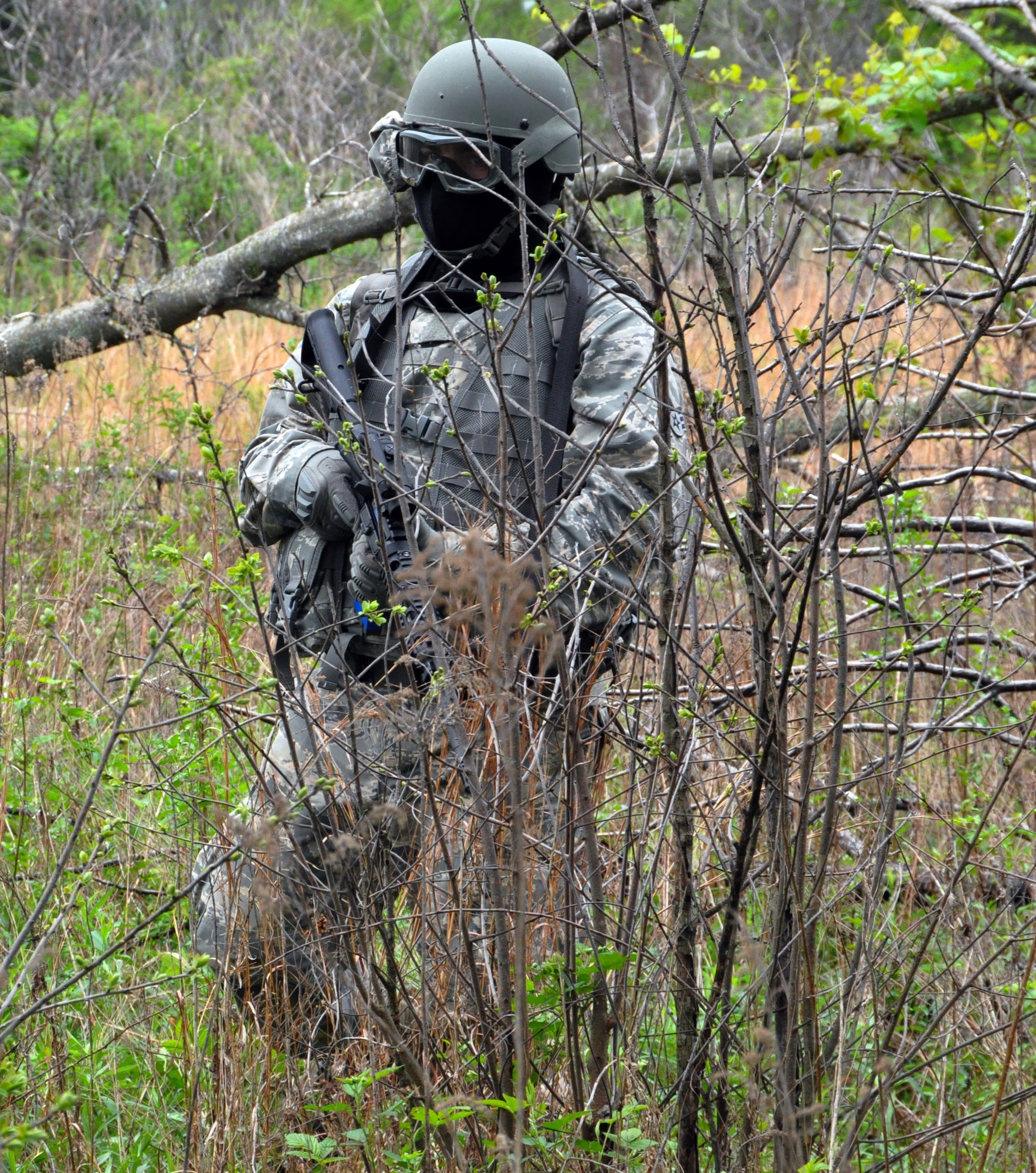 A member of the 931st Security Forces Squadron moves through terrain during a foot patrol training exercise at Camp Gruber Training Center, Okla., April 15, 2015.  More than 80 members of the 931 SFS and 931st Civil Engineer Squadron participated in ten days of combat skills training at Camp Gruber, which included land navigation, weapons training, tactical movements, convoy operations, base defense, room clearing procedures, foot patrols, military operations on urban terrain (MOUT) and combat lifesaving.  (U.S. Air Force photo by Capt. Zach Anderson)
