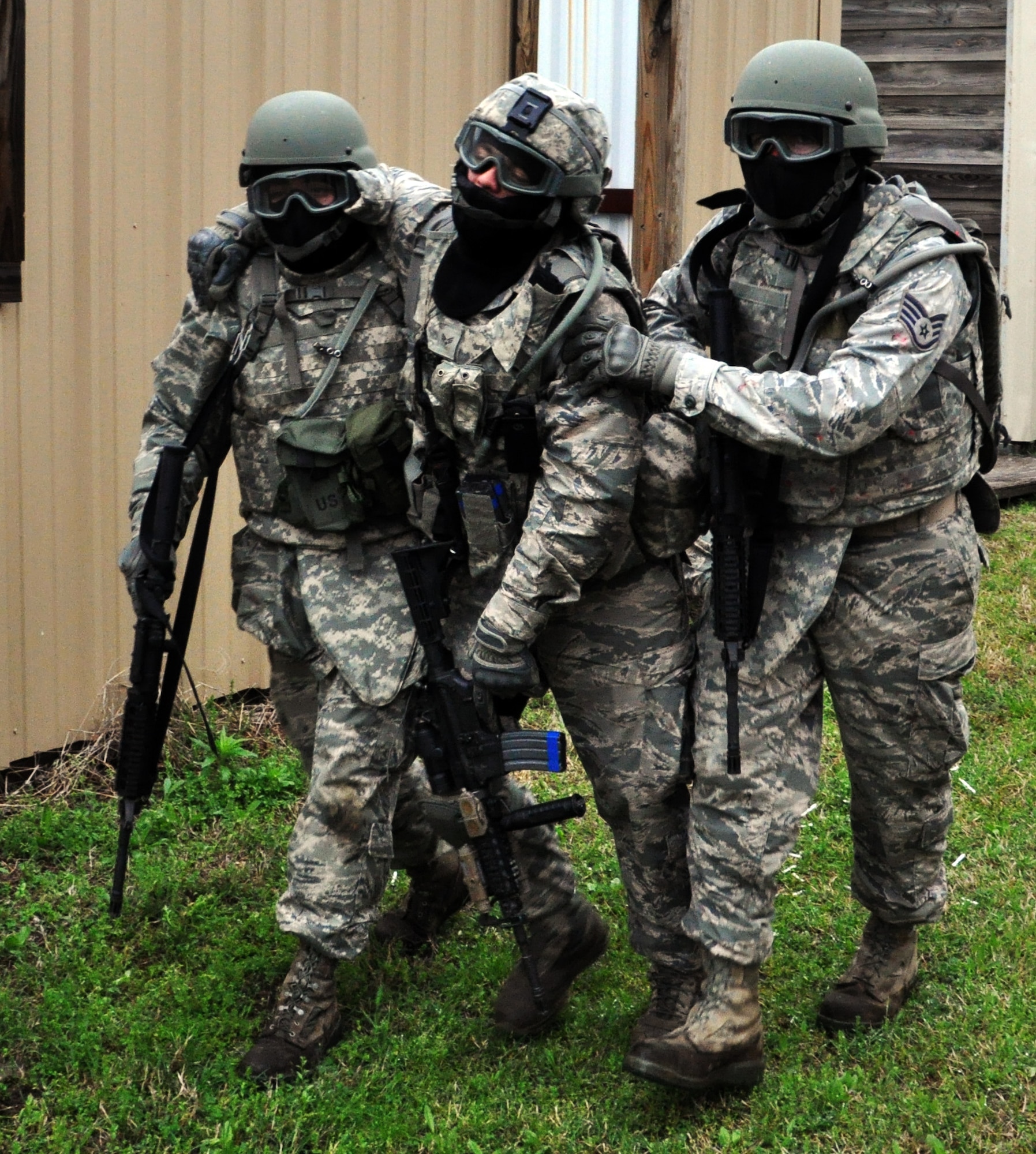 Members of the 931st Security Forces Squadron and 931st Civil Engineer Squadron assist a "wounded" Airman during a military operations on urban terrain (MOUT) exercise at Camp Gruber Training Center, Okla., April 15, 2015.  More than 80 members of the two squadrons participated in ten days of combat skills training at Camp Gruber, which included land navigation, weapons training, tactical movements, convoy operations, base defense, room clearing procedures, foot patrols, military operations on urban terrain (MOUT) and combat lifesaving.  (U.S. Air Force photo by Capt. Zach Anderson)
