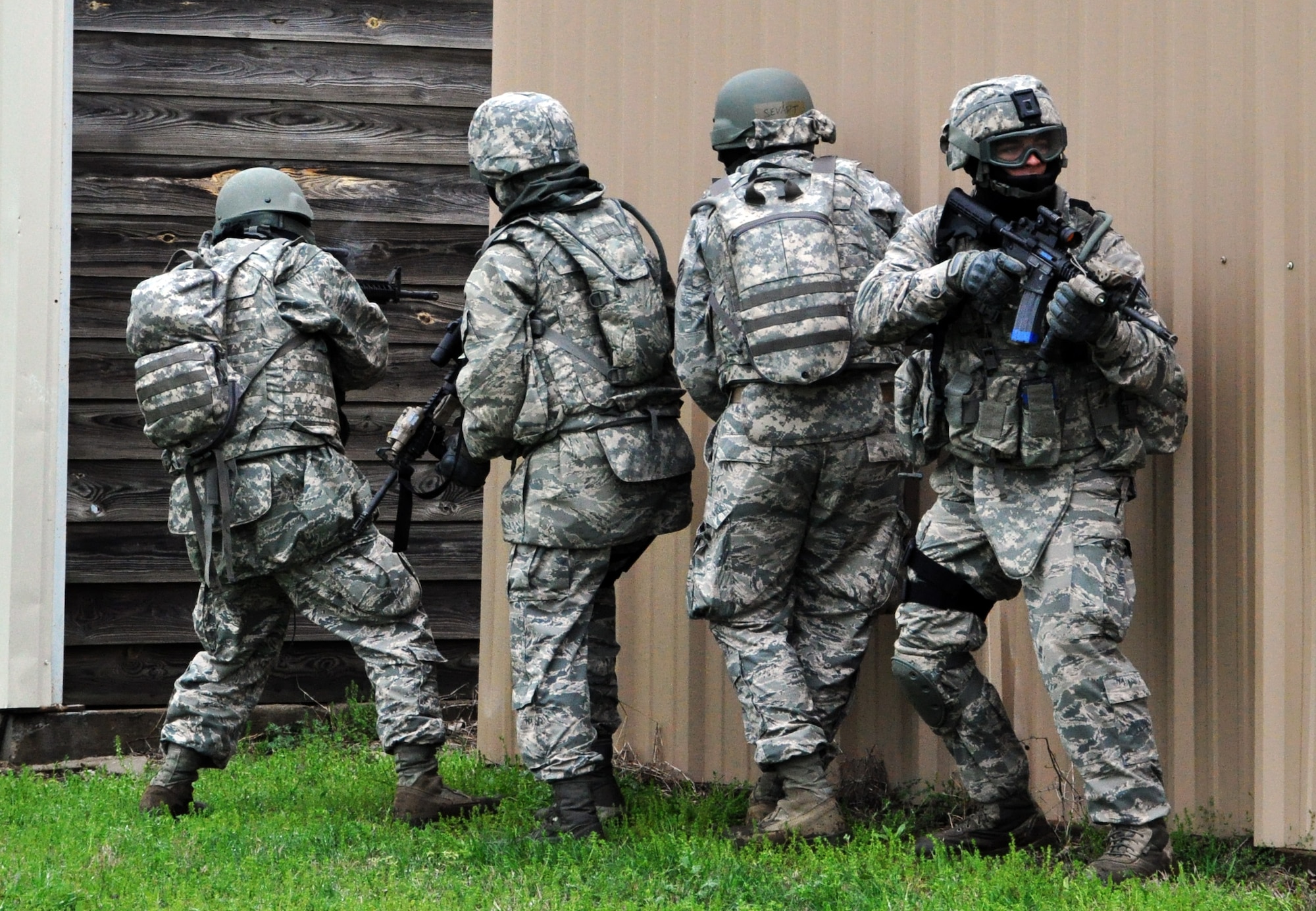 Members of the 931st Security Forces Squadron and 931st Civil Engineer Squadron perform an assault on opposing forces during a military operations on urban terrain (MOUT) exercise at Camp Gruber Training Center, Okla., April 15, 2015.  More than 80 members of the two squadrons participated in ten days of combat skills training at Camp Gruber, which included land navigation, weapons training, tactical movements, convoy operations, base defense, room clearing procedures, foot patrols, military operations on urban terrain (MOUT) and combat lifesaving.  (U.S. Air Force photo by Capt. Zach Anderson)
