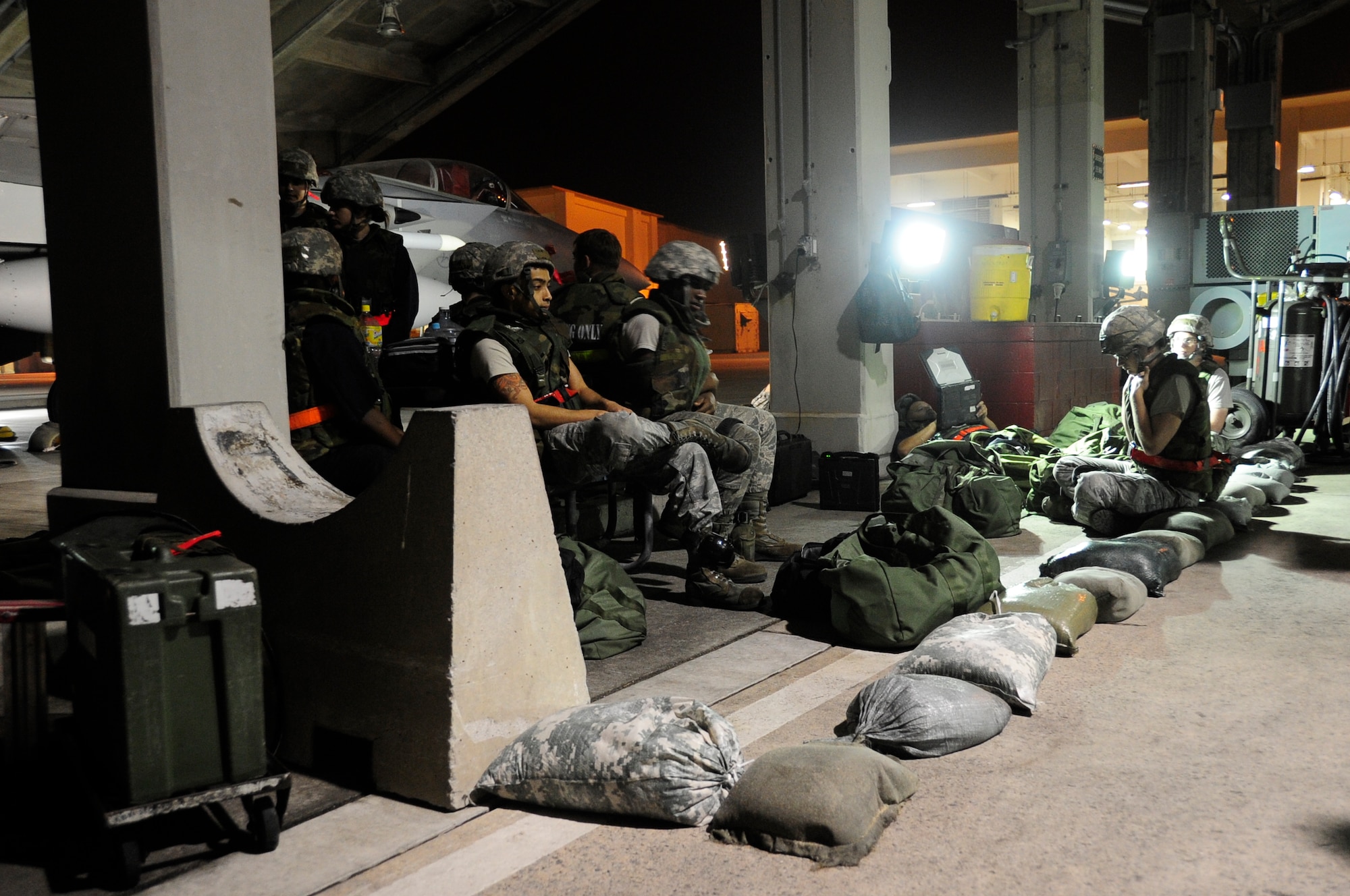 Airmen with the 67th Fighter Squadron take shelter in a simulated bunker on the flight line during Exercise Beverly High 15-2 at Kadena Air Base, Japan, April 20, 2015. The exercise tested the 18th Wings ability to deploy and react during contingency operations. (U.S. Air Force photo/Senior Airman Omari Bernard)
