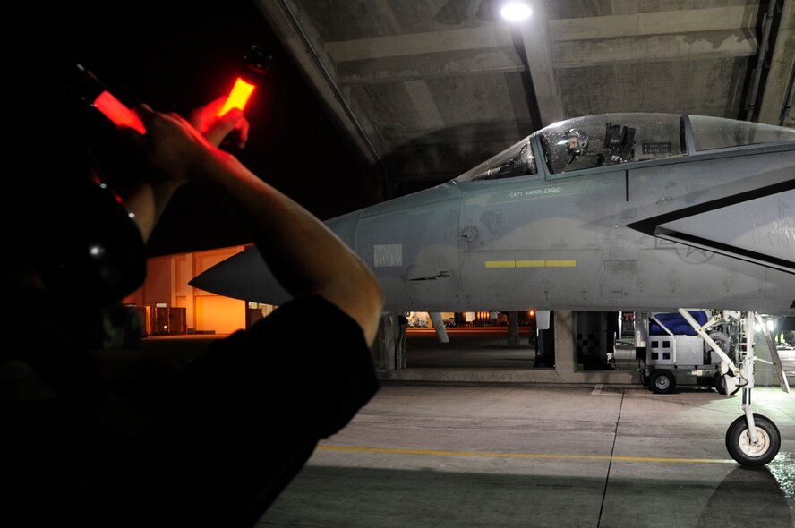 U.S. Air Force Capt. Aaron Ewing, an F-15 Eagle fighter pilot with 67th Fighter Squadron, is guided to a halt by his crew chief during Exercise Beverly High 15-2 at Kadena Air Base, Japan, April 20, 2015. The exercise tested the 18th Wings ability to deploy and react during contingency operations. (U.S. Air Force photo/Senior Airman Omari Bernard)