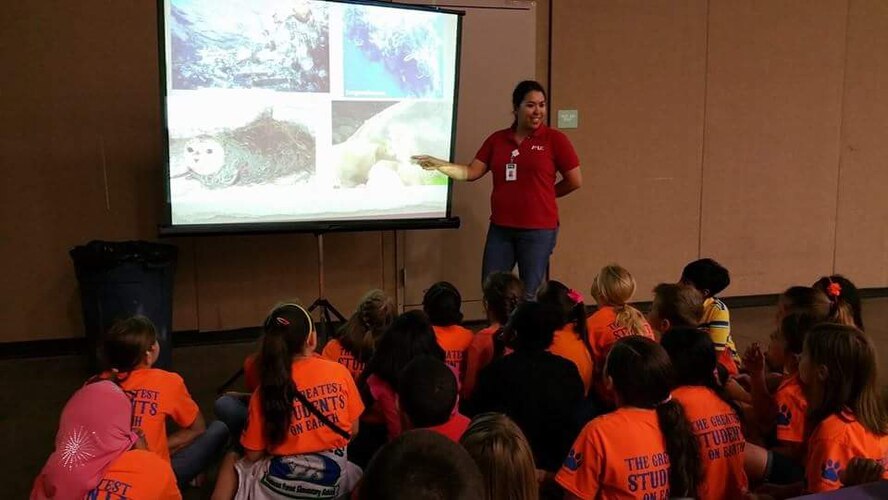 Leslie Peña,Natural Resource Manager for Sheppard Air Force Base, Texas, presents photographs from the Great Pacific Garbage Patch to stress the importance of recycling plastics and other products to young students at an event in Wichita Falls, Texas. (Courtesy photo)
