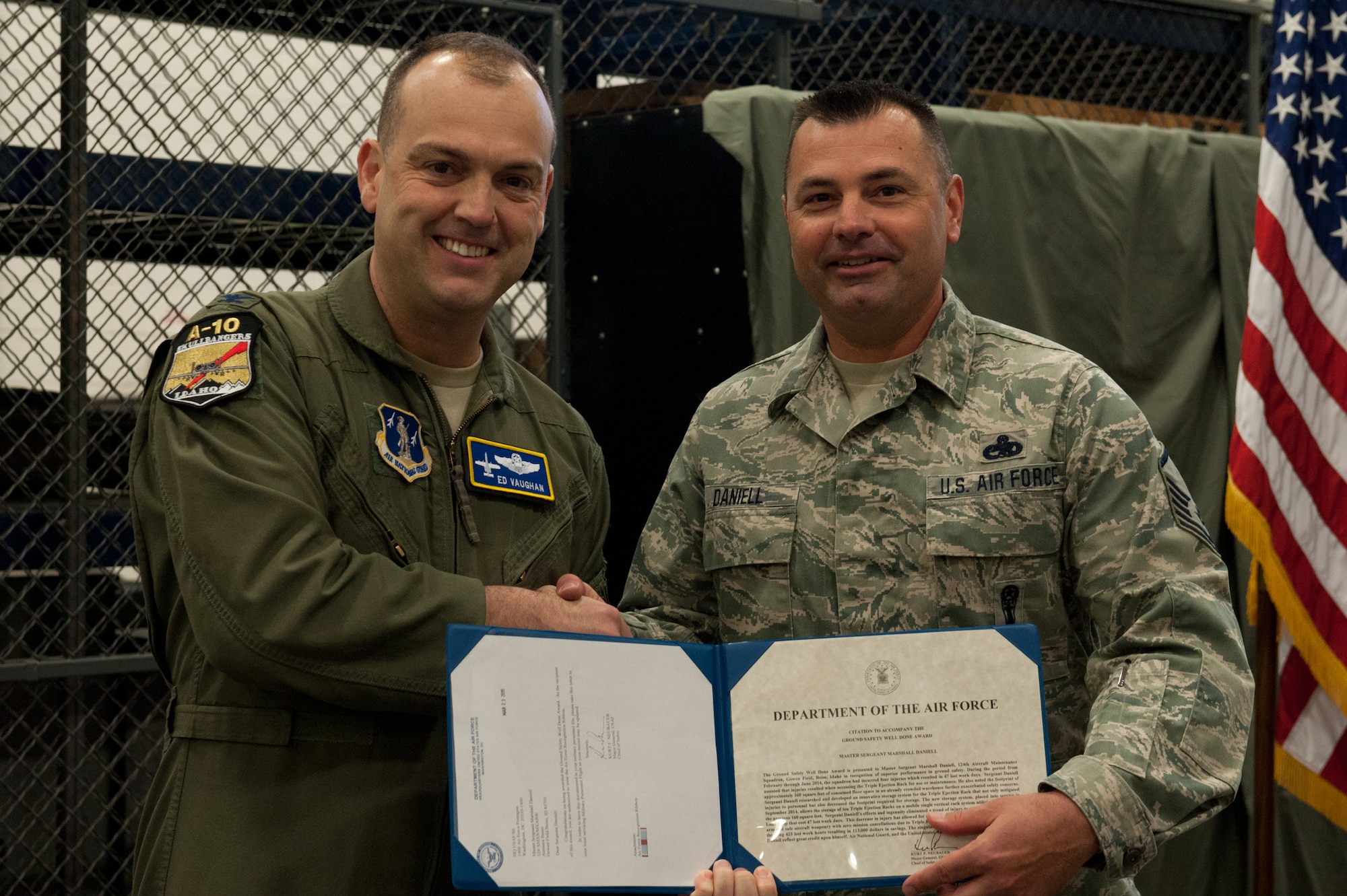 Master Sgt. Marshall J. Daniell, an armament systems specialist with the 124th Aircraft Maintenance Squadron Weapons Load Shop, is presented with an Air Force Ground Safety Well Done award from Col. Edward Vaughan, the director of safety for the Air National Guard, for researching and developing a storage system for the squadron???s Triple Ejection Racks April 12, 2015, at Gowen Field, Boise, Idaho. The TERs rack was previously stored on shelving units and is now stored on a mobile platform that can hold up to 10 racks. (Air National Guard photo by Tech. Sgt. Joshua Allmaras/Released)