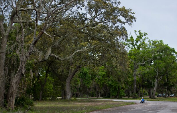 An Air Force Wounded Warrior athlete rides along a tree covered road during the third day of the Warrior Games training camp at Eglin Air Force Base, Fla., April 20. The five-day training camp for the Air Force’s athletes serves as their last practice session before the Warrior Games June 19-28. (U.S. Air Force photo/Samuel King Jr.)
