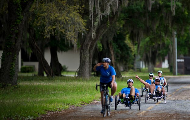 Air Force Wounded Warrior athletes ride along a tree covered road during the third day of the Warrior Games training camp at Eglin Air Force Base, Fla., April 20. The five-day training camp for the Air Force’s athletes serves as their last practice session before the Warrior Games June 19-28. (U.S. Air Force photo/Samuel King Jr.)