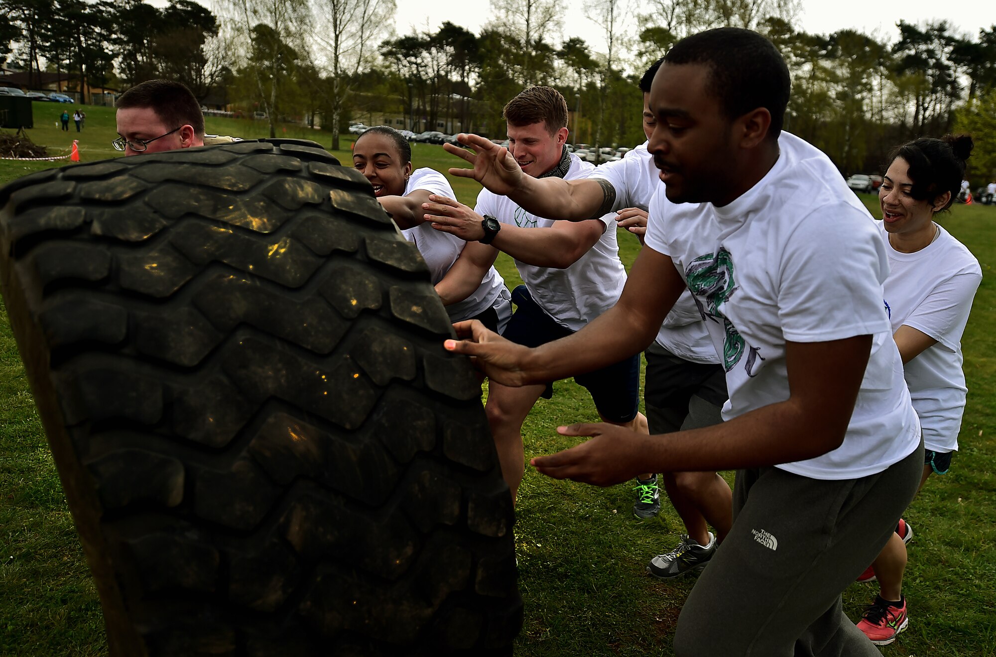 Team “Respect” from the 603rd Air and Space Communications Squadron flips a tire together during the Courage, Leadership, Education, Advocacy and Respect Challenge April 17, 2015, at Ramstein Air Base, Germany. The CLEAR Challenge was a physically and mentally challenging course symbolizing the effects of sexual assault and alcohol abuse. Teams competed to complete the tasks or obstacles for the best time. (U.S. Air Force photo/Staff Sgt. Sara Keller)