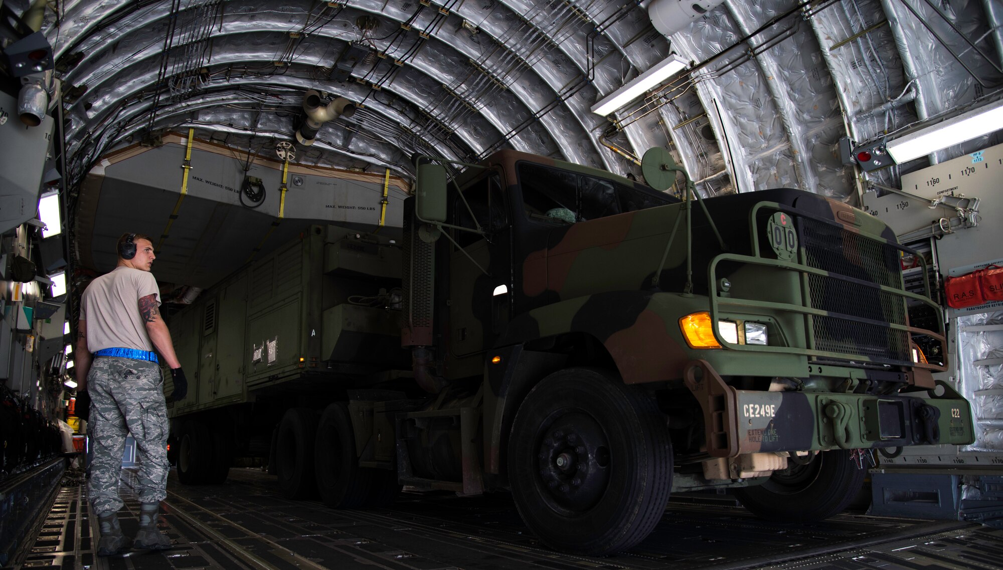 Staff Sgt. Preston Harris, 89th Aerial Port Squadron aircraft specialist, directs the loading of a U.S. Army truck into a C-17 Globemaster III at Joint Base Andrews, Md., April 15, 2015. Two generators and five pallets of cargo were loaded by 89 APS in support of a joint-military airlift operation to Romania. (U.S. Air Force photo/Airman 1st Class Philip Bryant)