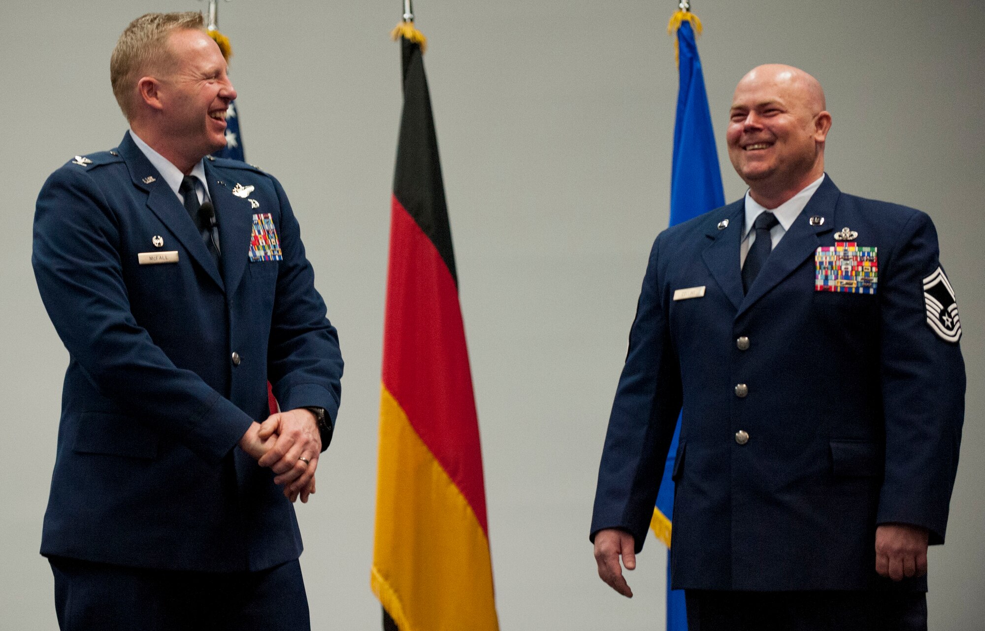 U.S. Air Force Col. Joe McFall, 52nd Fighter Wing commander, left, looks on as U.S. Air Force Senior Master Sgt. Christopher Collins, 52nd Civil Engineer Squadron facilities systems superintendent, right, speaks during the  52nd Mission Support Group commander’s call at the Skelton Memorial Fitness Center in Spangdahlem Air Base, Germany, April 16, 2015. McFall presented two medals to Collins for his actions during a deployment to Afghanistan in 2013. (U.S. Air Force photo by Airman 1st Class Timothy Kim/Released)