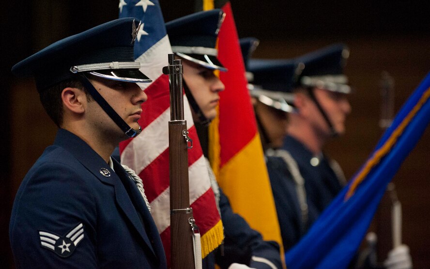 The 52nd Fighter Wing Honor Guard present the colors during the playing of the German and American national anthems during a 52nd Mission Support Group commander’s call at the Skelton Memorial Fitness Center in Spangdahlem Air Base, Germany, April 16, 2015. U.S. Air Force Senior Master Sgt. Christopher Collins, 52nd Civil Engineer Squadron facilities systems superintendent, received a Bronze Star Medal and a Combat Action Medal during the commander's call for his actions while deployed to Afghanistan in 2013. (U.S. Air Force photo by Airman 1st Class Timothy Kim/Released)