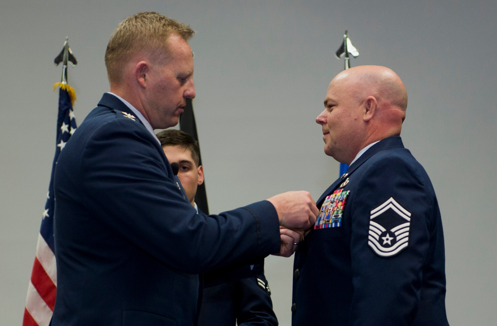 U.S. Air Force Col. Joe McFall, 52nd Fighter Wing commander, left, pins a Bronze Star Medal on U.S. Air Force Senior Master Sgt. Christopher Collins, 52nd Civil Engineer Squadron facilities systems superintendent, right, during a 52nd Mission Support Group commander’s call at the Skelton Memorial Fitness Center in Spangdahlem Air Base, Germany, April 16, 2015. Collins earned the Bronze Star Medal and the Combat Action Medal for his actions during his deployment in Afghanistan in 2013. (U.S. Air Force photo by Airman 1st Class Timothy Kim/Released)