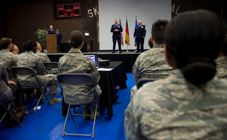 U.S. Air Force Col. Joe McFall, 52nd Fighter Wing commander, center left, and U.S. Air Force Senior Master Sgt. Christopher Collins, 52nd Civil Engineer Squadron facilities systems superintendent, center right, stand on a stage during the 52nd Mission Support Group commander’s call at the Skelton Memorial Fitness Center in Spangdahlem Air Base, Germany, April 16, 2015. McFall spoke of Collins’ accomplishments before presenting him with a Bronze Star medal and a Combat Action medal. (U.S. Air Force photo by Airman 1st Class Timothy Kim/Released)