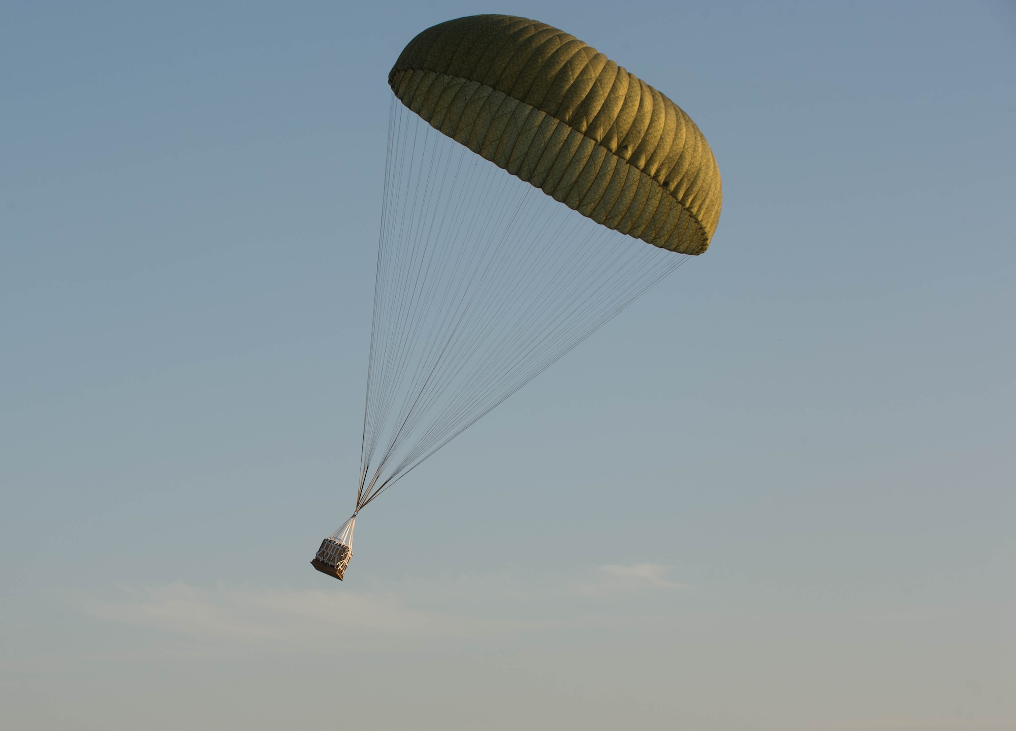 A container delivery system is air dropped for the first time onto Powidz Air Base, Poland, April 15, 2015. The 37th Airlift Squadron had the honor of air dropping the bundle. Approximately 130 service members from throughout Europe along with Airmen from the 302nd Airlift Wing arrived to Powidz to train alongside their Polish counterparts as part of an aviation detachment rotation. (U.S. Air Force photo/Senior Airman Jonathan Stefanko)