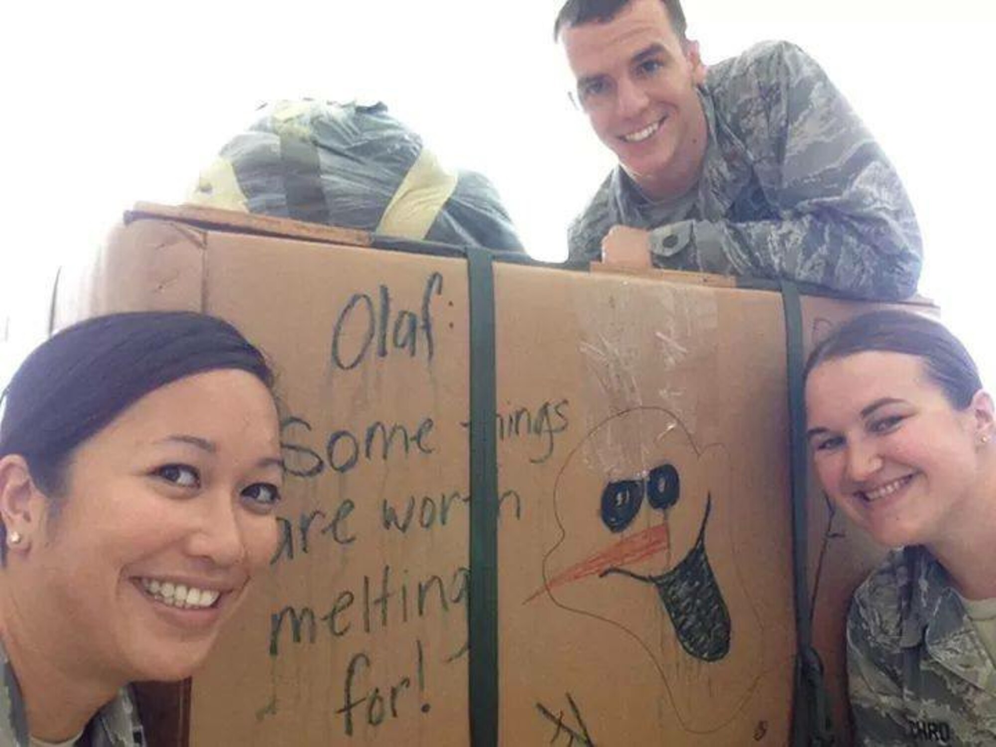 2nd Lt. Victoria Cachro (right), 36th Wing Plans, Programs and Readiness strategic planner, poses in front of a finished packaged box for Operation Christmas Drop in Hangar 3, Dec., 2014. Cachro volunteered more than 1,500 hours to the base and local community during the past year. (Courtesy photo)