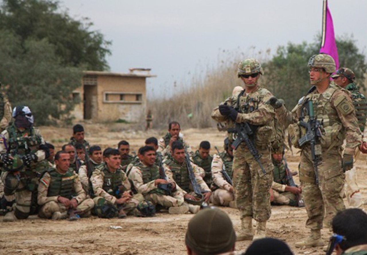 Iraqi army soldiers with 73rd Brigade, 15th Division, look on as U.S. instructors from the 3rd Brigade Combat Team, 82nd Airborne Division, discuss movement techniques and squad-level tactics at a training area on Camp Taji, Iraq, March 24, 2015. U.S. Army photo by Sgt. Cody Quinn