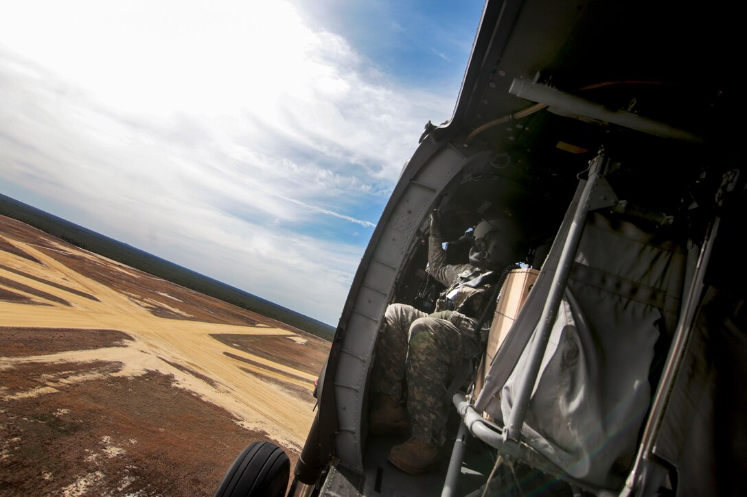 Army Sgt. Justin Davis looks out over Coyle drop zone before participating in aerial gunnery training at the Army Aviation Support Facility on Joint Base McGuire-Dix-Lakehurst, N.J., April 16, 2015. Davis is a crew chief assigned to the New Jersey Army National Guard's 1st Battalion, 150th Assault Helicopter Battalion.