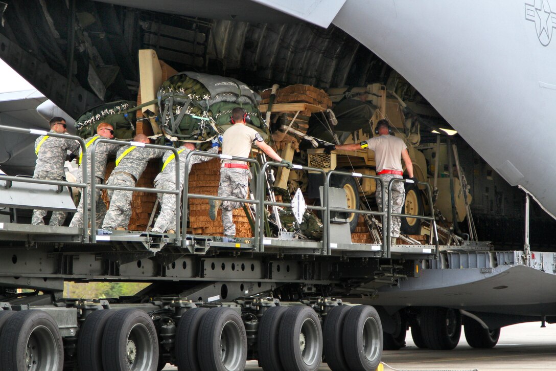 Army paratroopers and Air Force airmen load vehicles and equipment onto a C-17 Globemaster III aircraft on Pope Army Airfield, N.C., April 13, 2015.