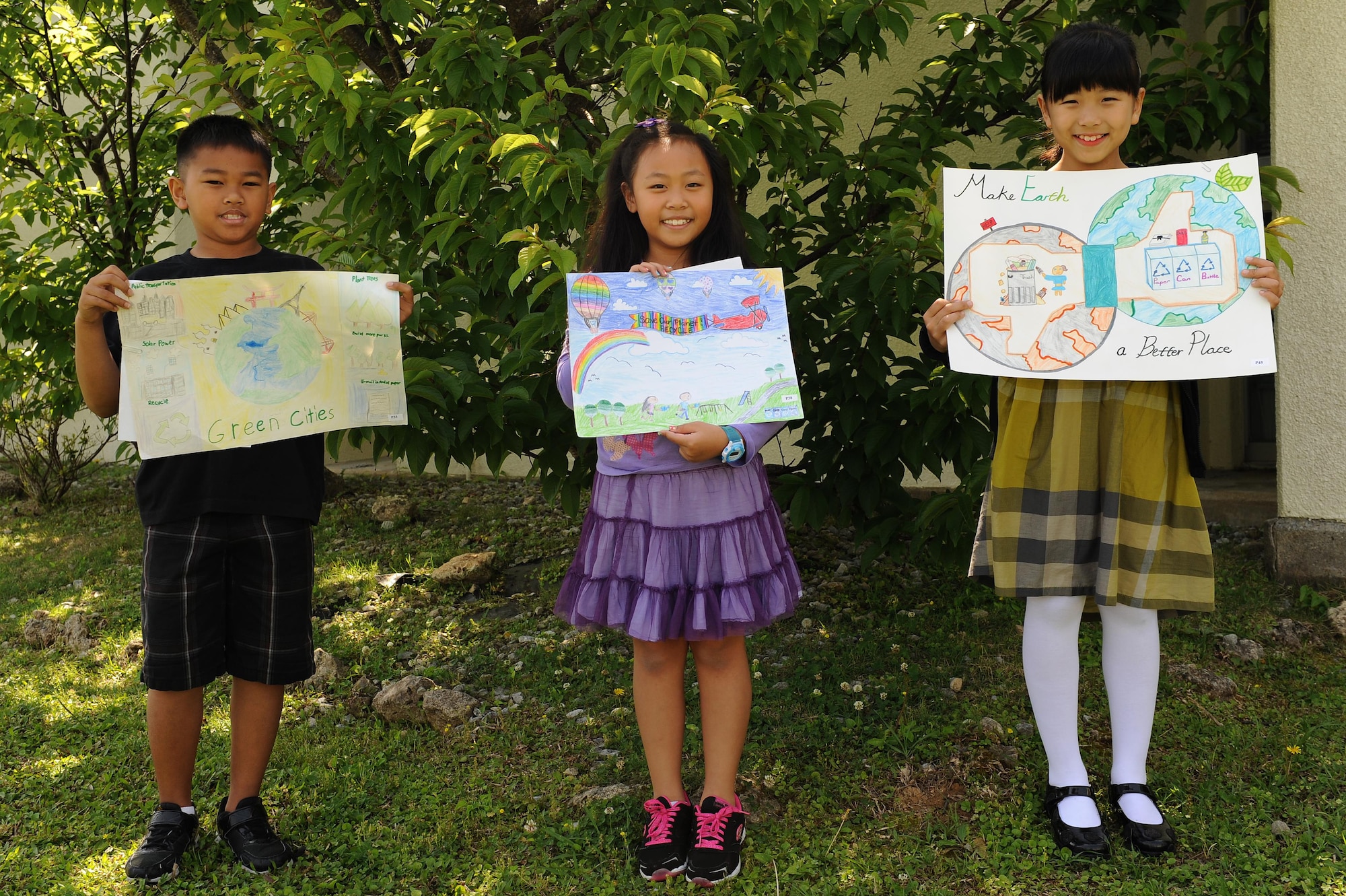 Jayvin Quitano, Miri Skylen Chang and Clair Lim, Amelia Earhart Intermediate School students, pose with their winning submissions for the 718th Civil Engineer Squadron environmental office’s Earth Day art contest on Kadena Air Base, Japan, April 17, 2015. The contest, which was open to students at all Kadena schools, was intended to raise awareness for environmental conservation. (U.S. Air Force photo/Airman 1st Class Zade C. Vadnais)