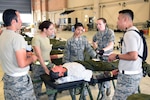 Airmen from the 59th Medical Wing, Joint Base San Antonio-Lackland, Texas, discuss a simulated patient's care during aeromedical evacuation processing in an Ultimate Caduceus 2015 exercise at Naval Air Station Joint Reserve Base New Orleans on April 16, 2015.  Ultimate Caduceus 2015 consists of approximately 140 military personnel representing Active Duty, National Guard and Reserve Forces from California, Delaware, Illinois, Kansas, Louisiana, Maryland, Mississippi, Texas and Washington, D.C.