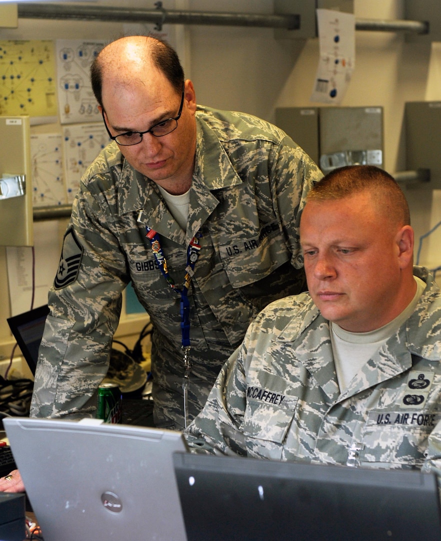 Air Force Master Sgt. Jeptha Gibbs, a member of the 102nd Network Warfare Squadron of the Rhode Island Air National Guard watches Master Sgt. Darryl McCaffrey also of the 102nd as he protects the computer network from malicious activity during a communications exercise during Combined Endeavor. Combined Endeavor 2010 is the world's largest communications interoperability exercise, preparing international forces' command, control, communications and computer systems for multinational operations.