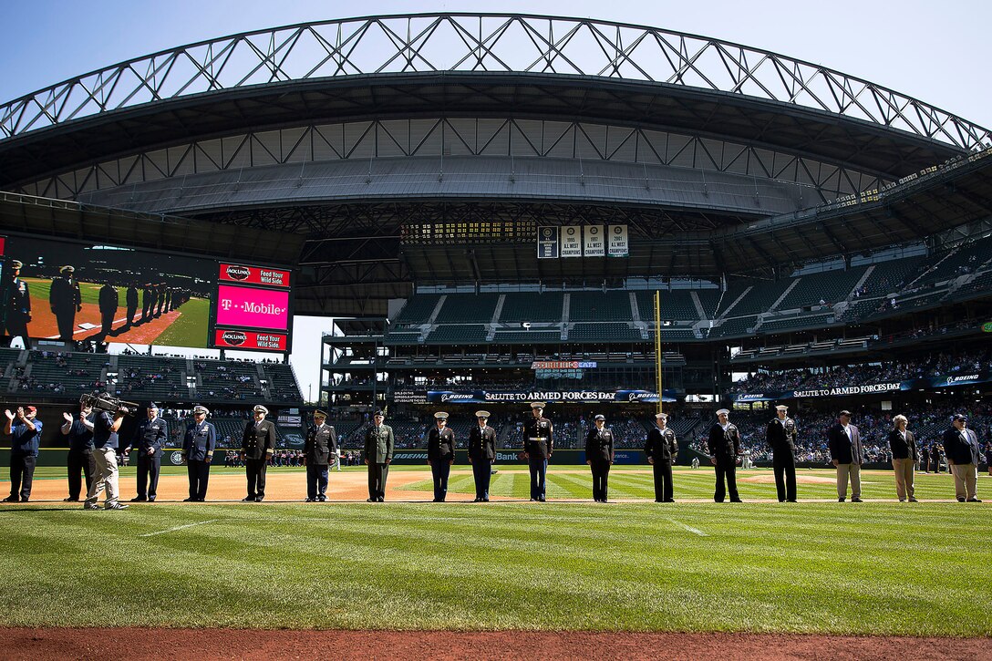 SEATTLE -- Service members from western Washington State line the base paths during the opening ceremonies of a Seattle Mariners' Salute to Armed Forces game at Safeco Field here, April 19, 2015. The event included the presentation of commemorative plaques to senior military leaders, a joint-service color guard and flag presentation, military band performances and ceremonial first pitches thrown out by members of each service. (U.S. Marine Corps photo by Sgt. Reece Lodder)