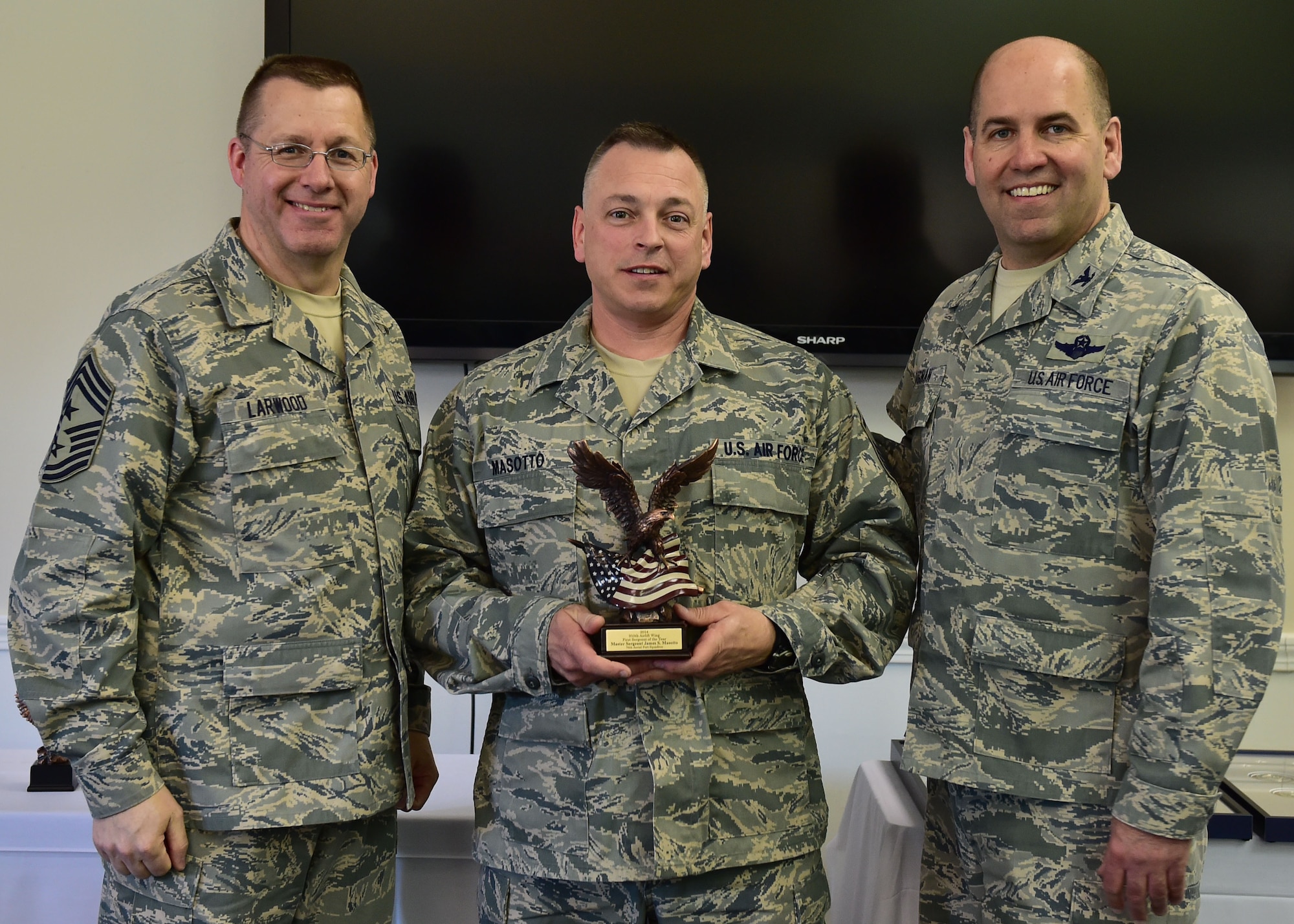 910th Airlift Wing 2014 First Sergeant of the Year, Master Sgt. James Masotto, poses with 910th Airlift Wing Command Chief Master Sgt. Steven Larwood and 910th Airlift Wing Commander Col. James Dignan, after receiving his award at a ceremony April 12. Masotto is the first sergeant of the 76th Aerial Port Squadron here. (U.S. Air Force photo/Senior Airman Rachel Kocin)